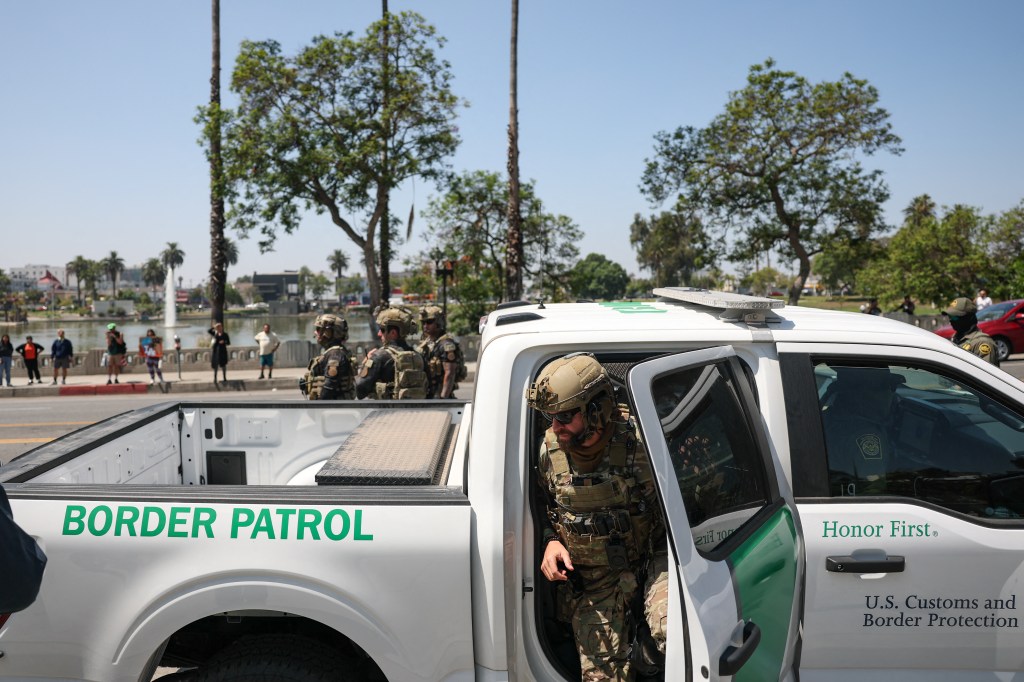 A U.S. Customs and Border Protection agent exiting a Border Patrol vehicle.
