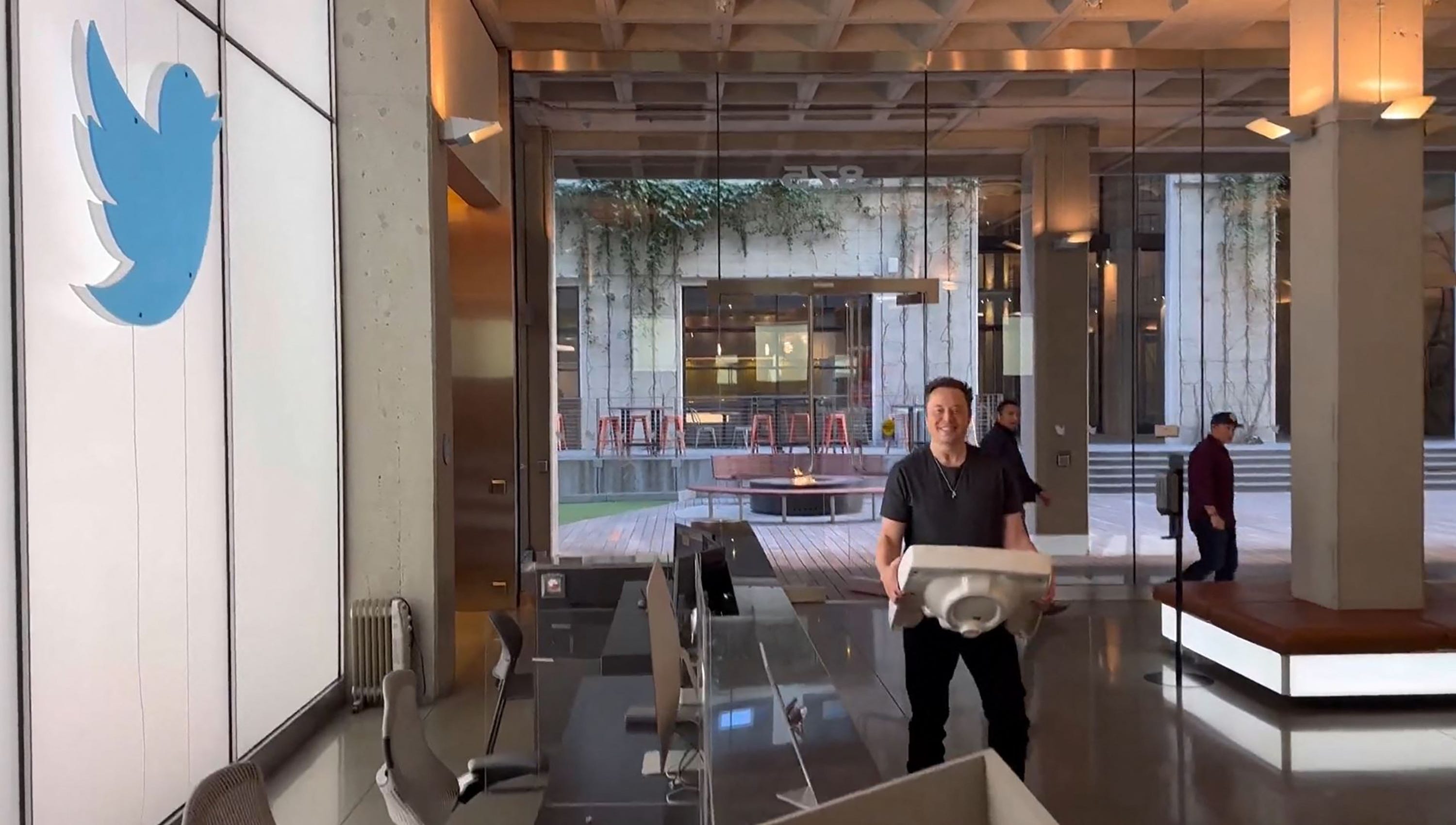 Elon Musk, carrying a sink, enters the Twitter headquarters in San Francisco.