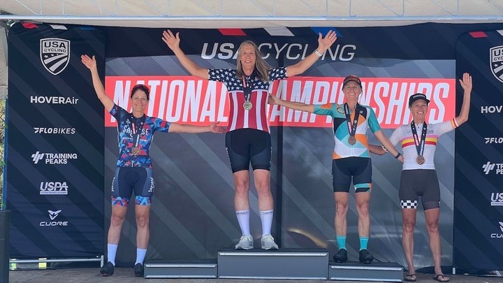 Four women on a cycling awards podium.