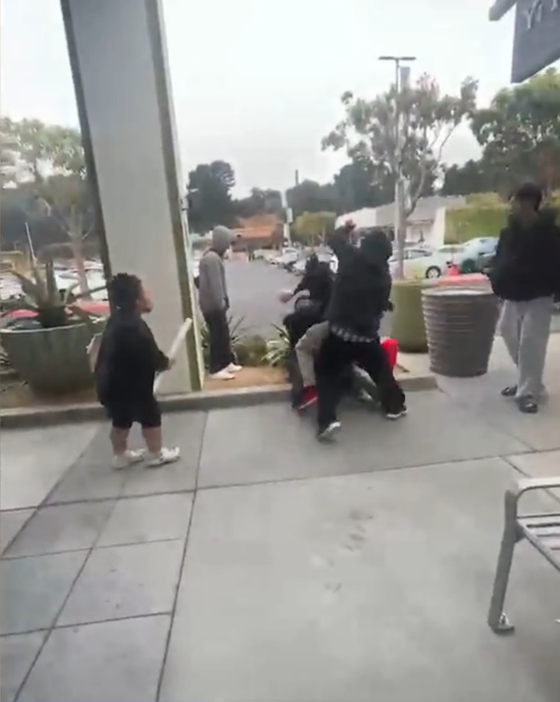 People fighting in a parking lot.