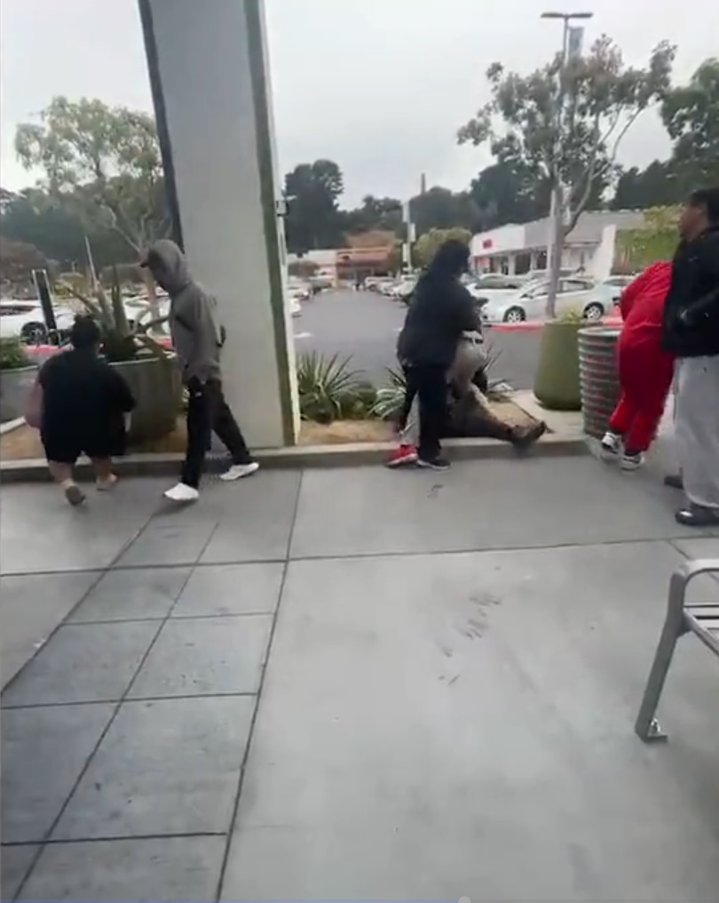 People standing around a person lying on the ground.