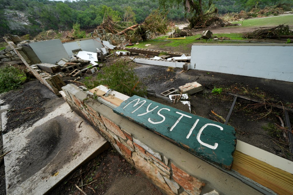 A Camp Mystic sign is seen near the entrance to the establishment along the banks of the Guadalupe River after a flash flood swept through the area in Hunt, Texas, Saturday, July 5, 2025. 