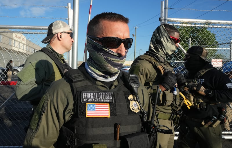 Immigration and Customs Enforcement (ICE) agents stand near a gate at Delaney Hall, a newly converted immigrant detention centre in Elizabeth, New Jersey
