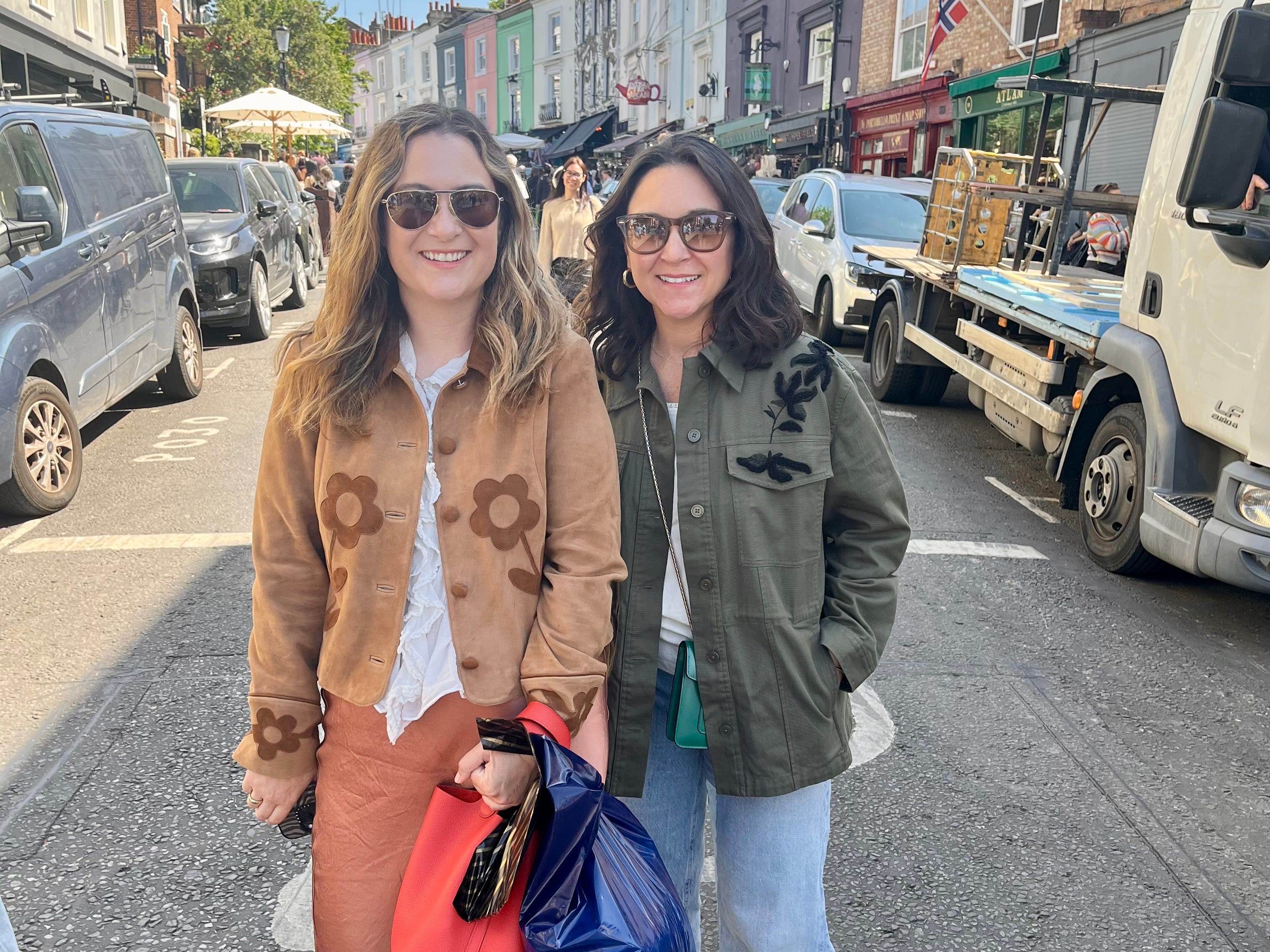 The author and her sister wearing embroidered jackets and sunglasses standing in the middle of a street in San Francisco.