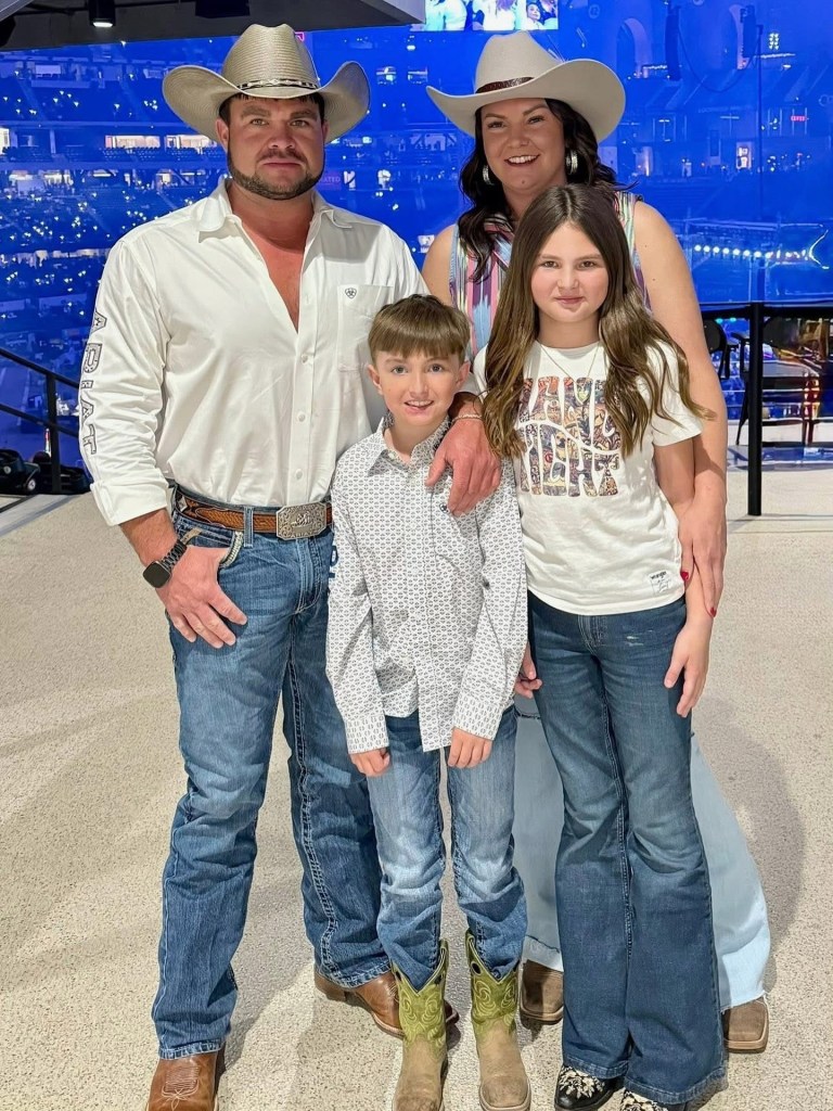 Family portrait of four people wearing cowboy hats and jeans.