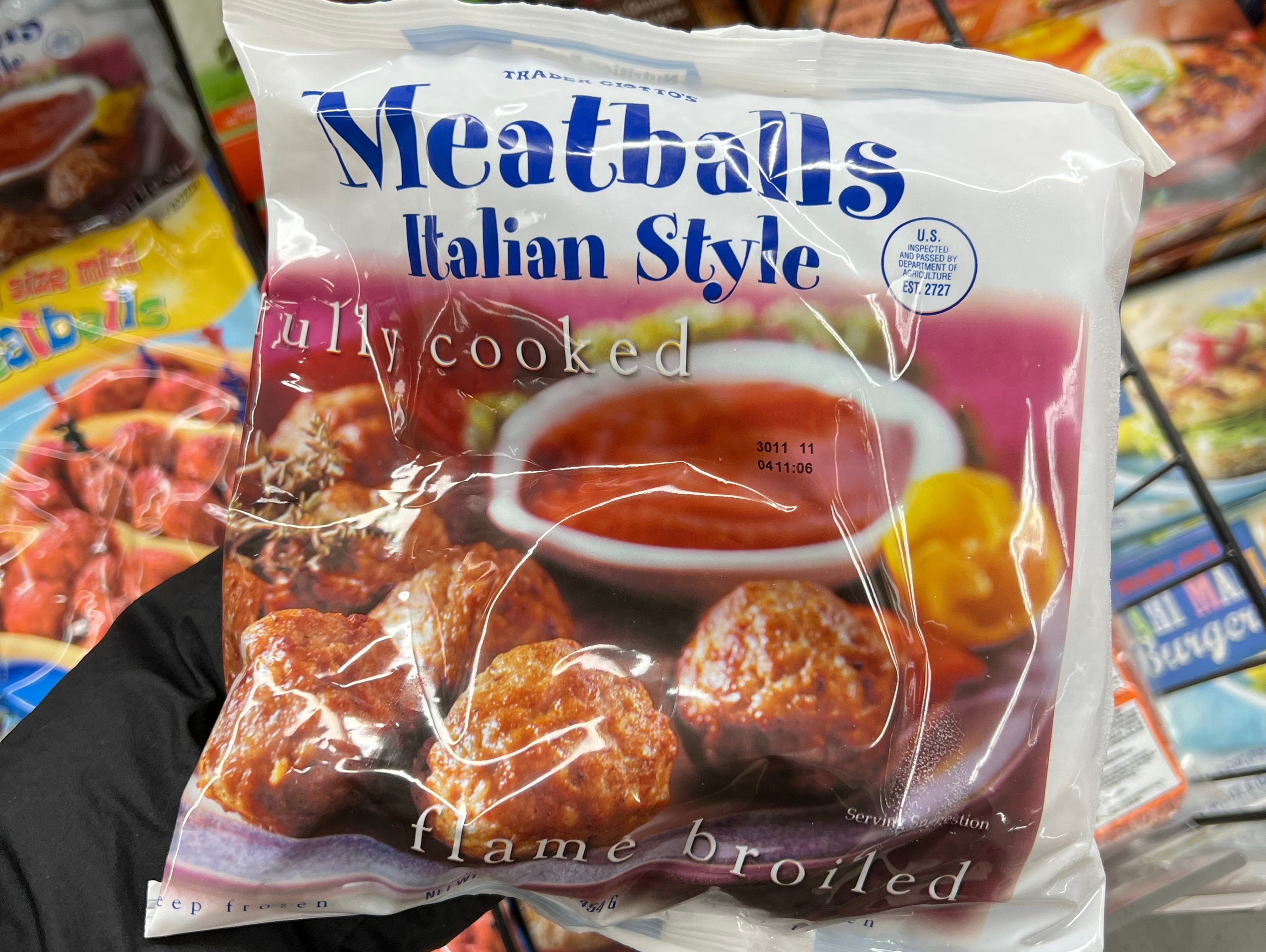 The writer holds a pack of frozen meatballs