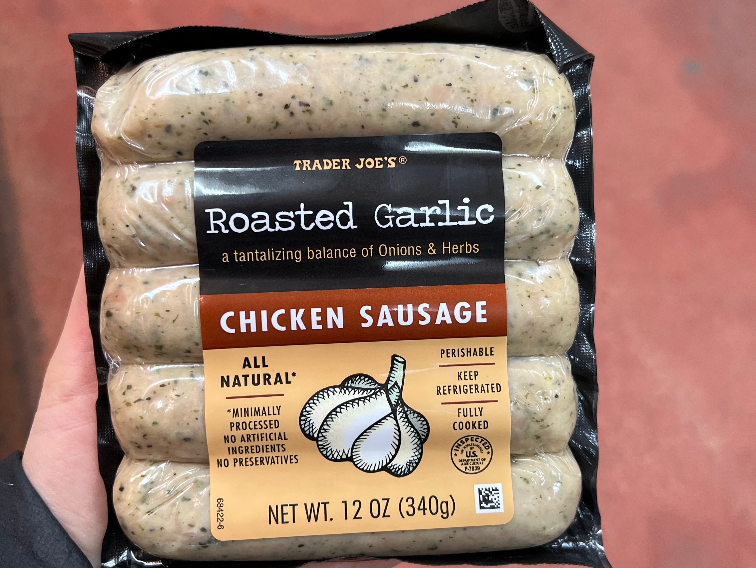 The writer holds a package of roasted garlic-chicken sausage