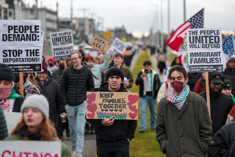 People hold signs during a march against Immigration and Customs Enforcement (ICE) entitled "Get our Gente Out of Guantanamo Bay!" in Seattle in February.