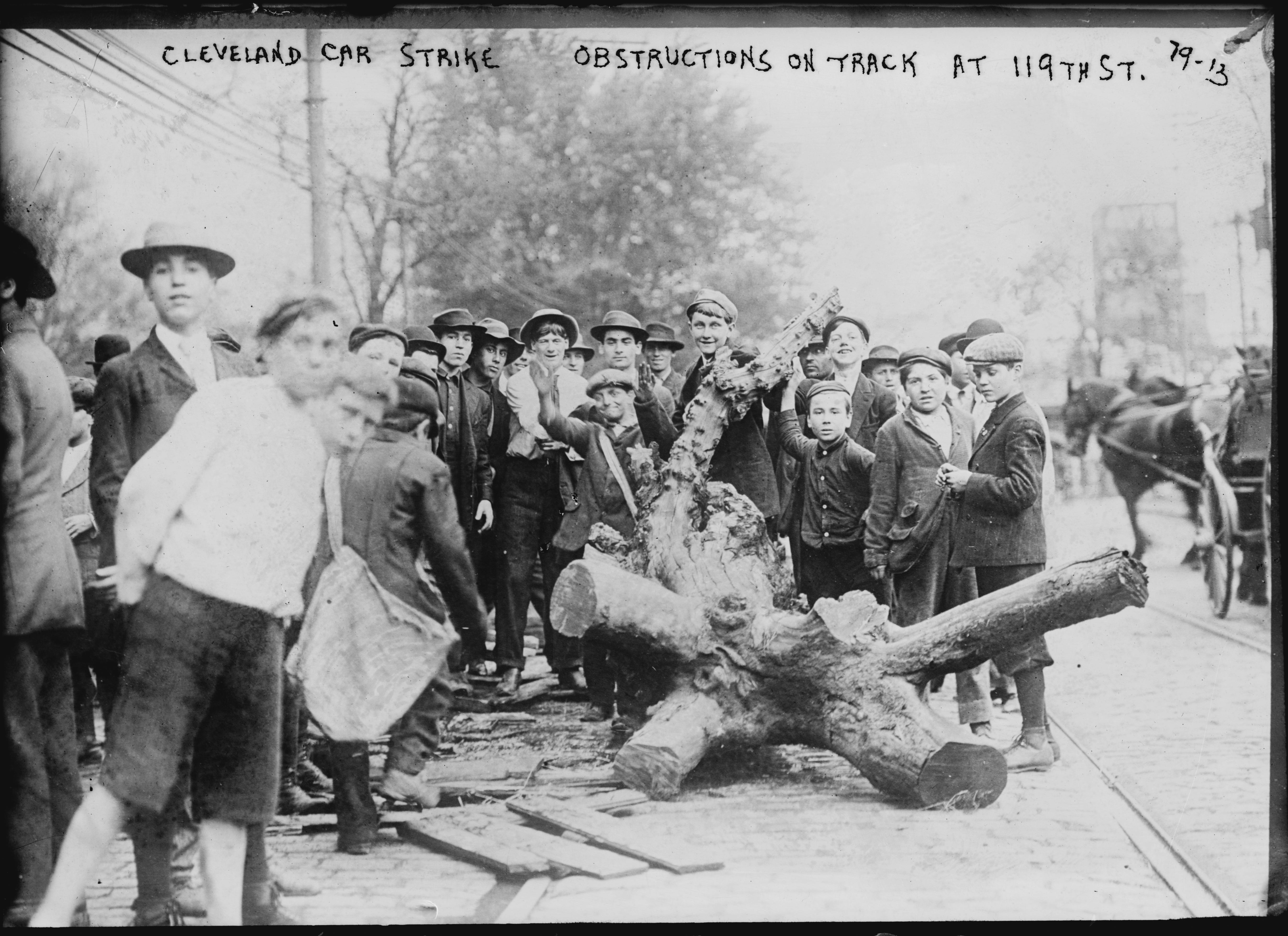 Men and boys gather around strike obstructions set up during the Cleveland Car Strike, on 119th Street, Ohio, 1899