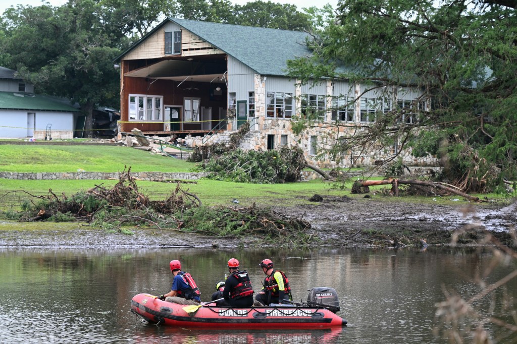 A search and rescue crew drive on the Guadalupe River past Camp Mystic in Hunt, Texas on July 7, 2025.