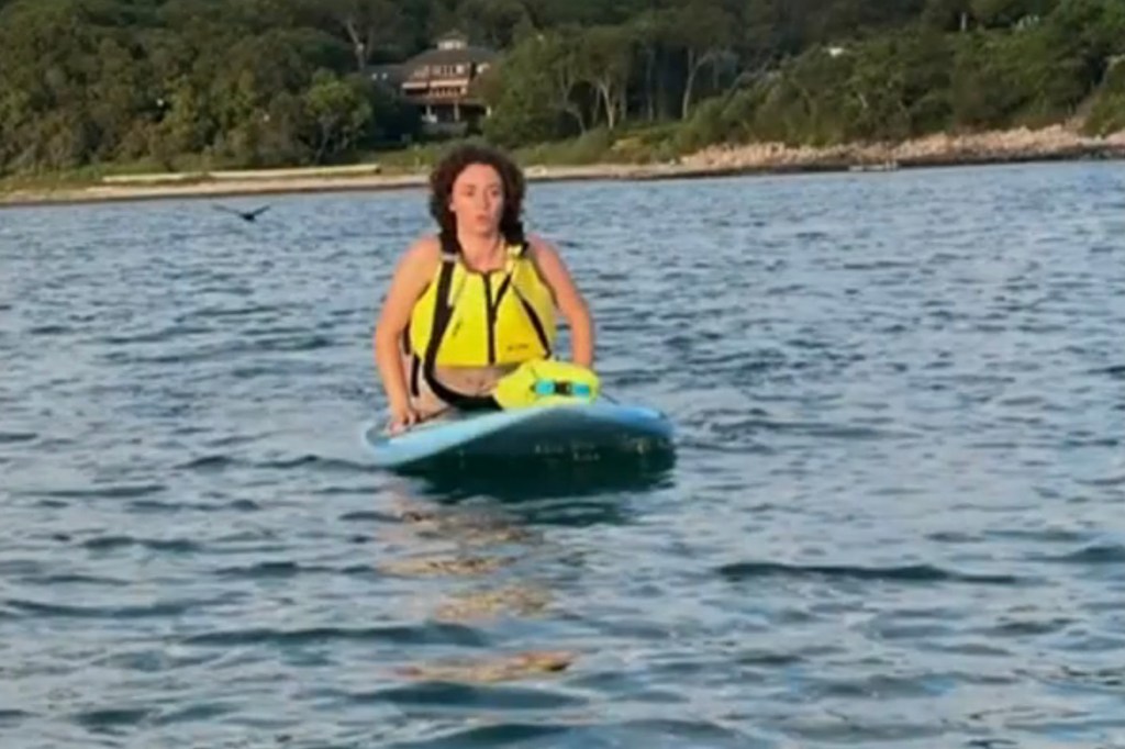 Margaret Bowles sits on her paddleboard after seeing the shark pass by.