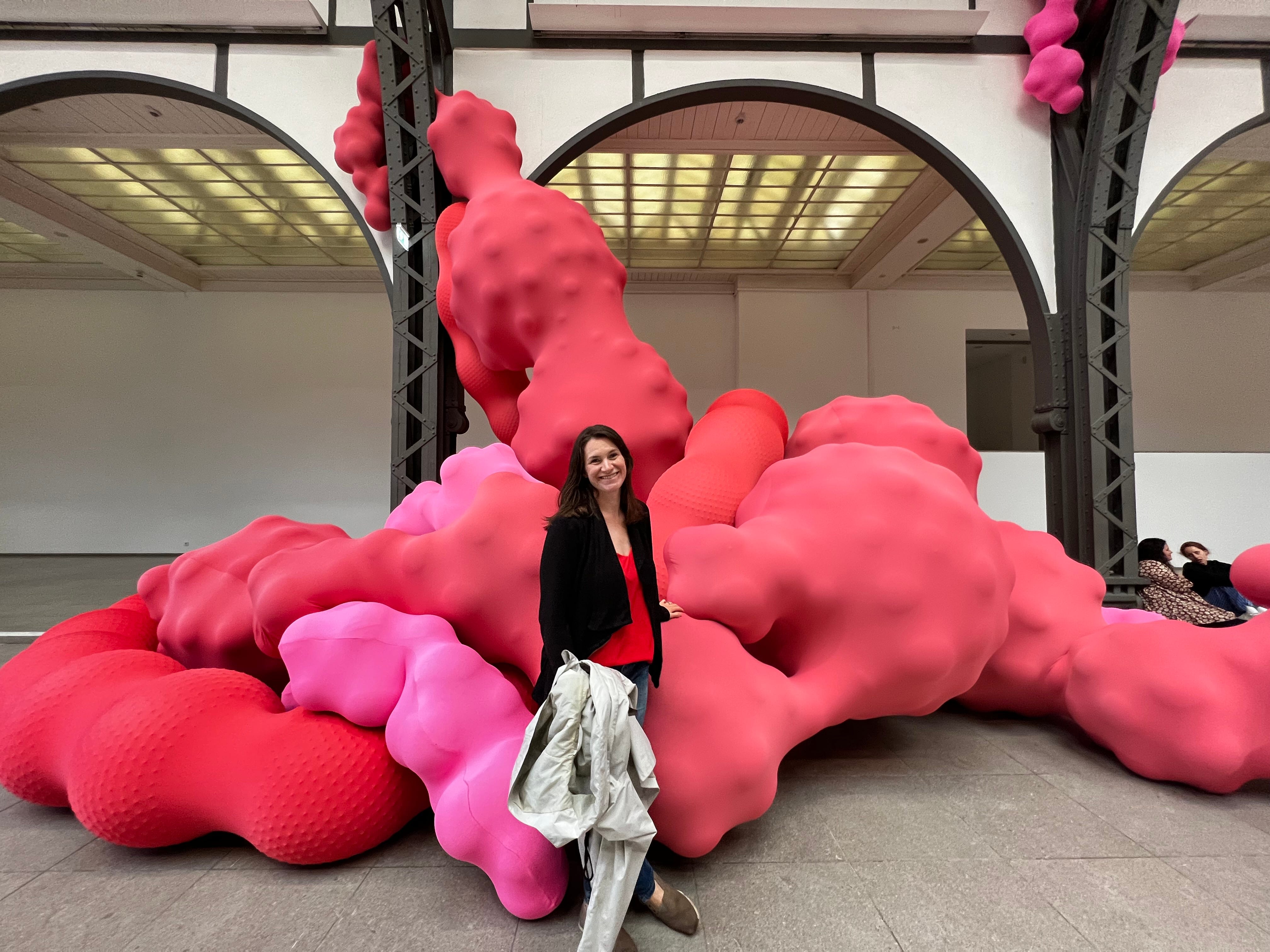 Kate Chrisman in front of a giant red sculpture blob