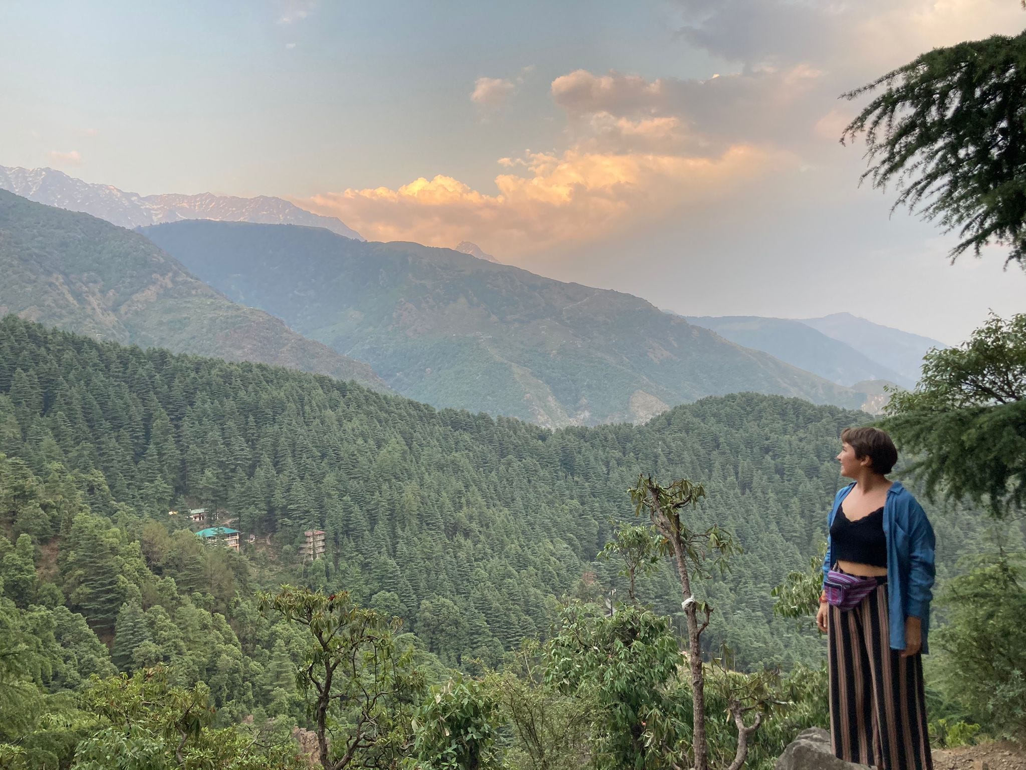 Author Katie Lemon smiling in front of tree-covered mountains