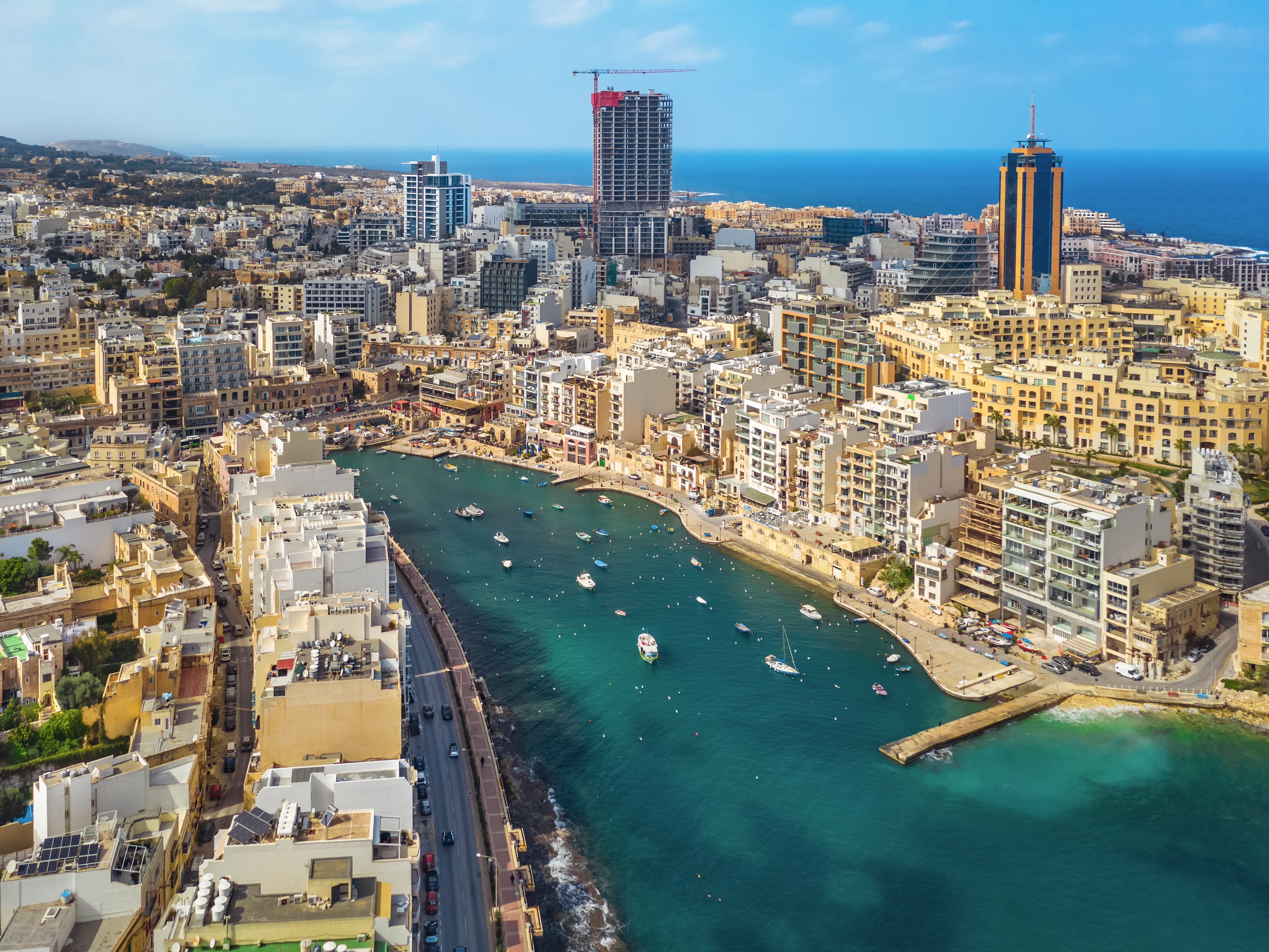 An aerial view of a city with a turquoise bay.