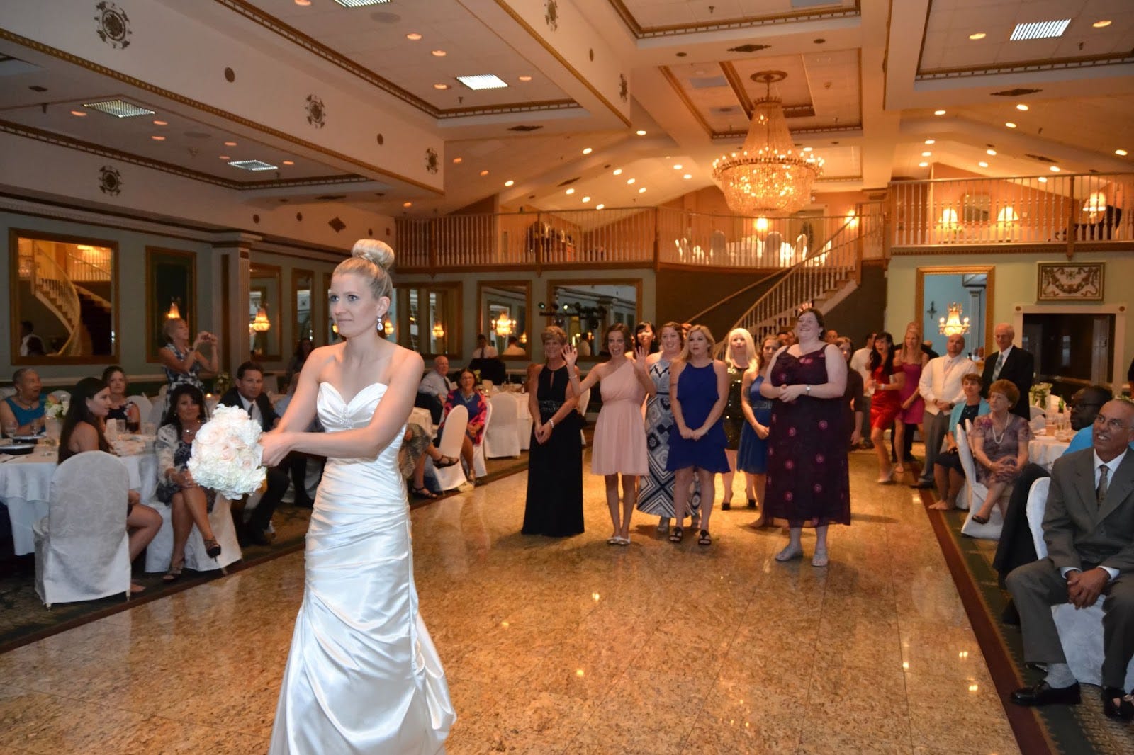 Bride getting ready to toss boquet to group of women behind her