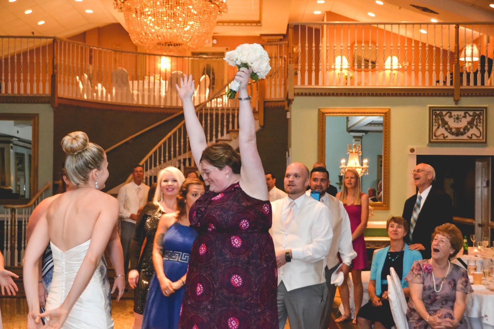 Woman holding boquet next to bride at a wedding