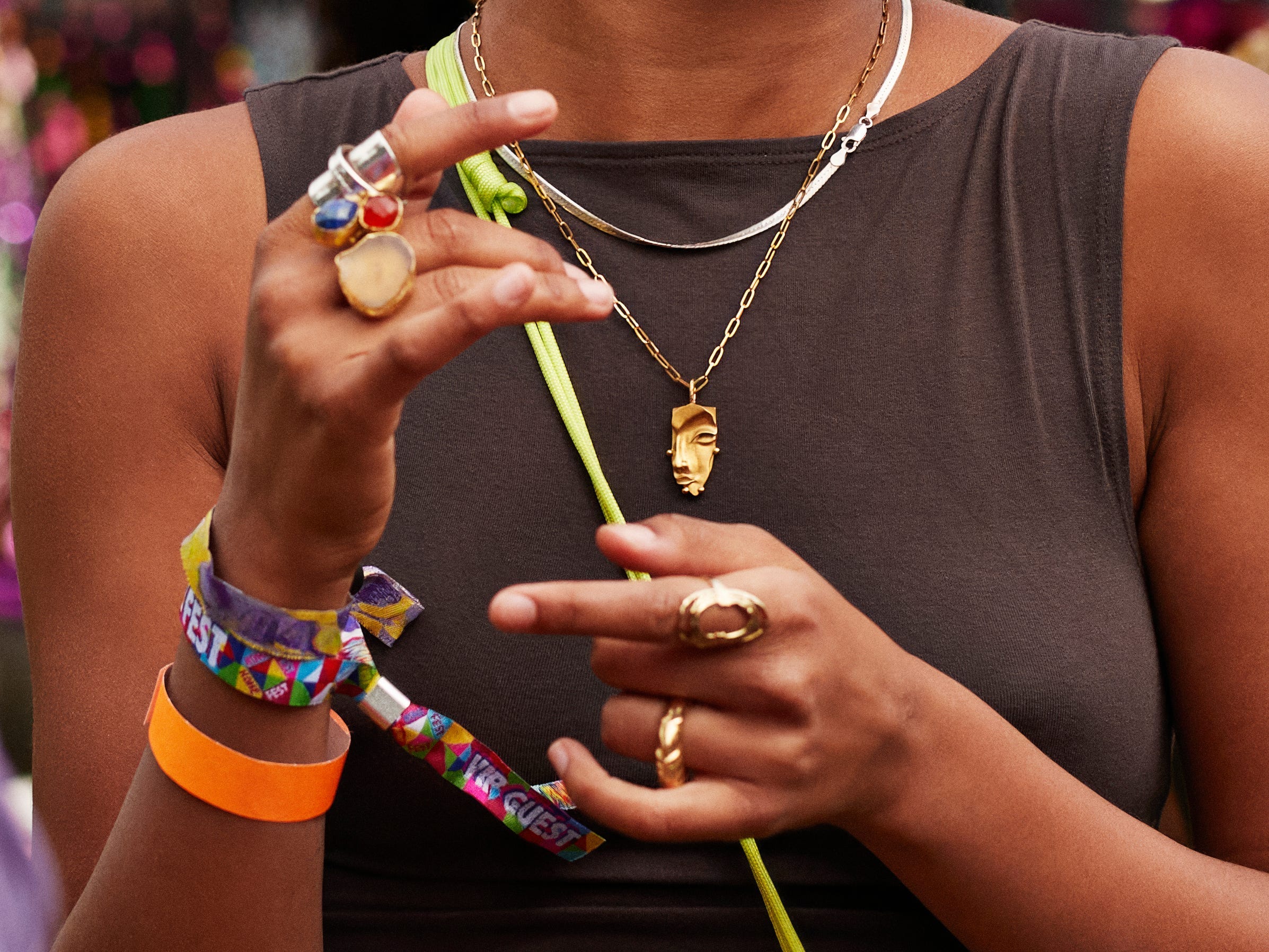 woman laughing at a vintage market while wearing a brown shirt, fuzzy sunglasses, and lots of rings