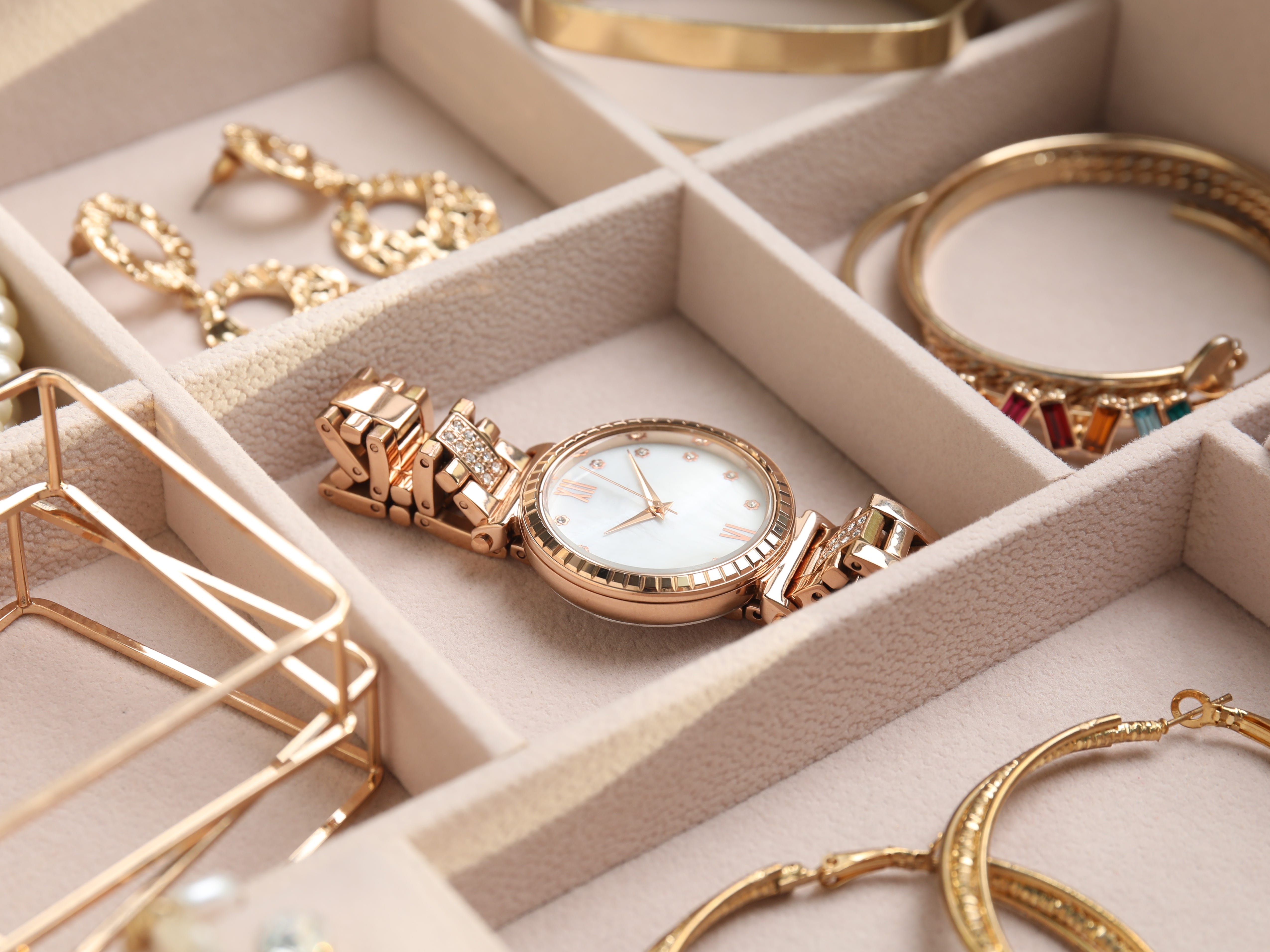 jewelry neatly displayed in an organizer with a watch in the middle