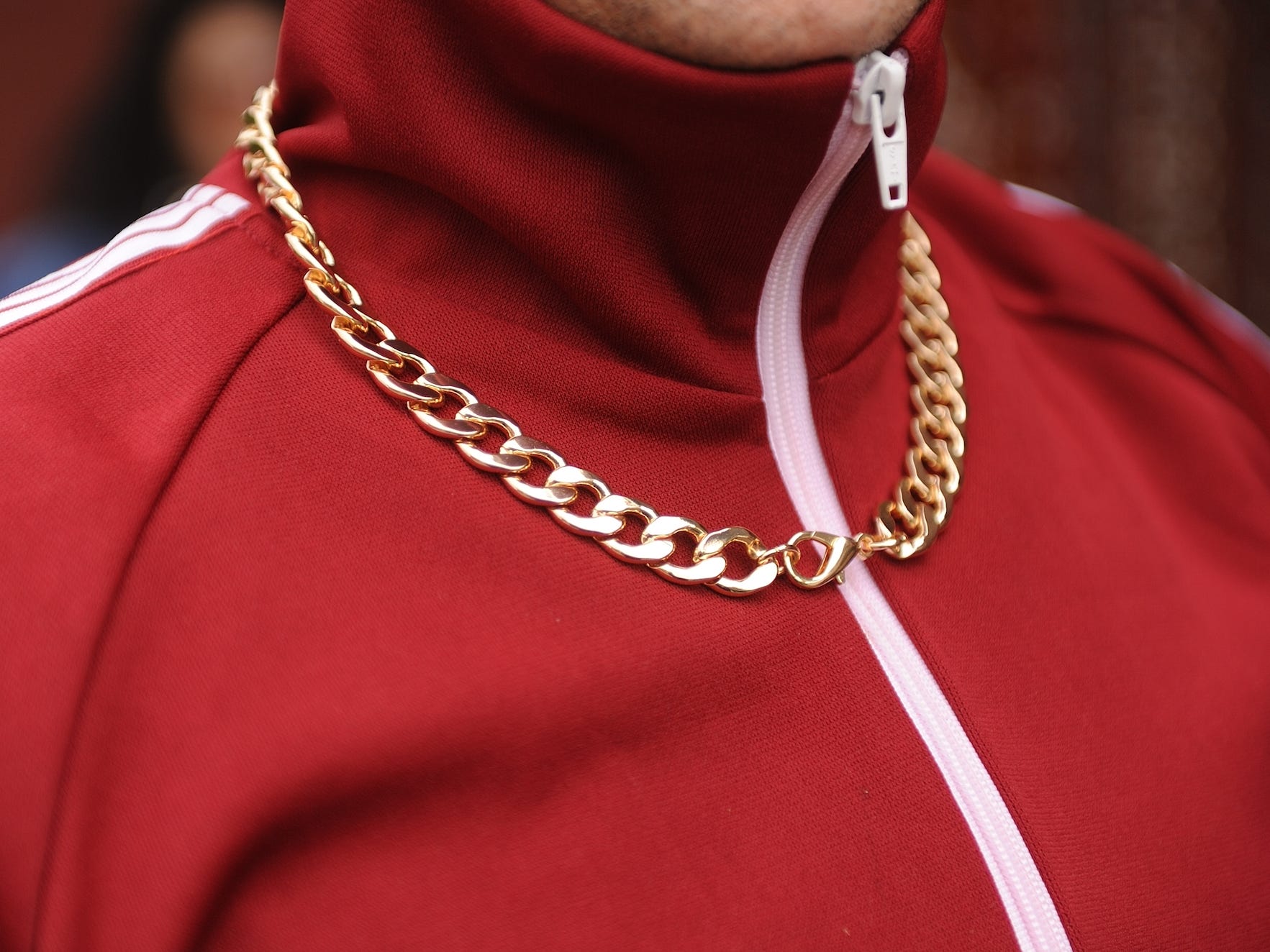 close up of someone wearing a red track jacket and a gold chain
