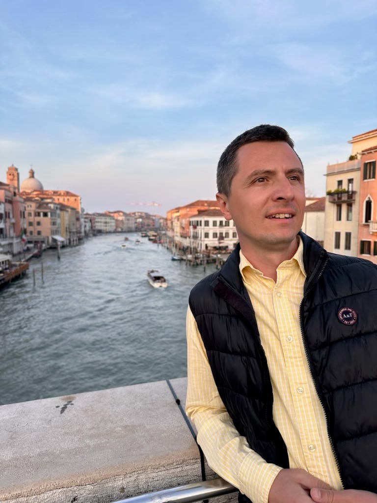 A man standing above a canal in Italy.