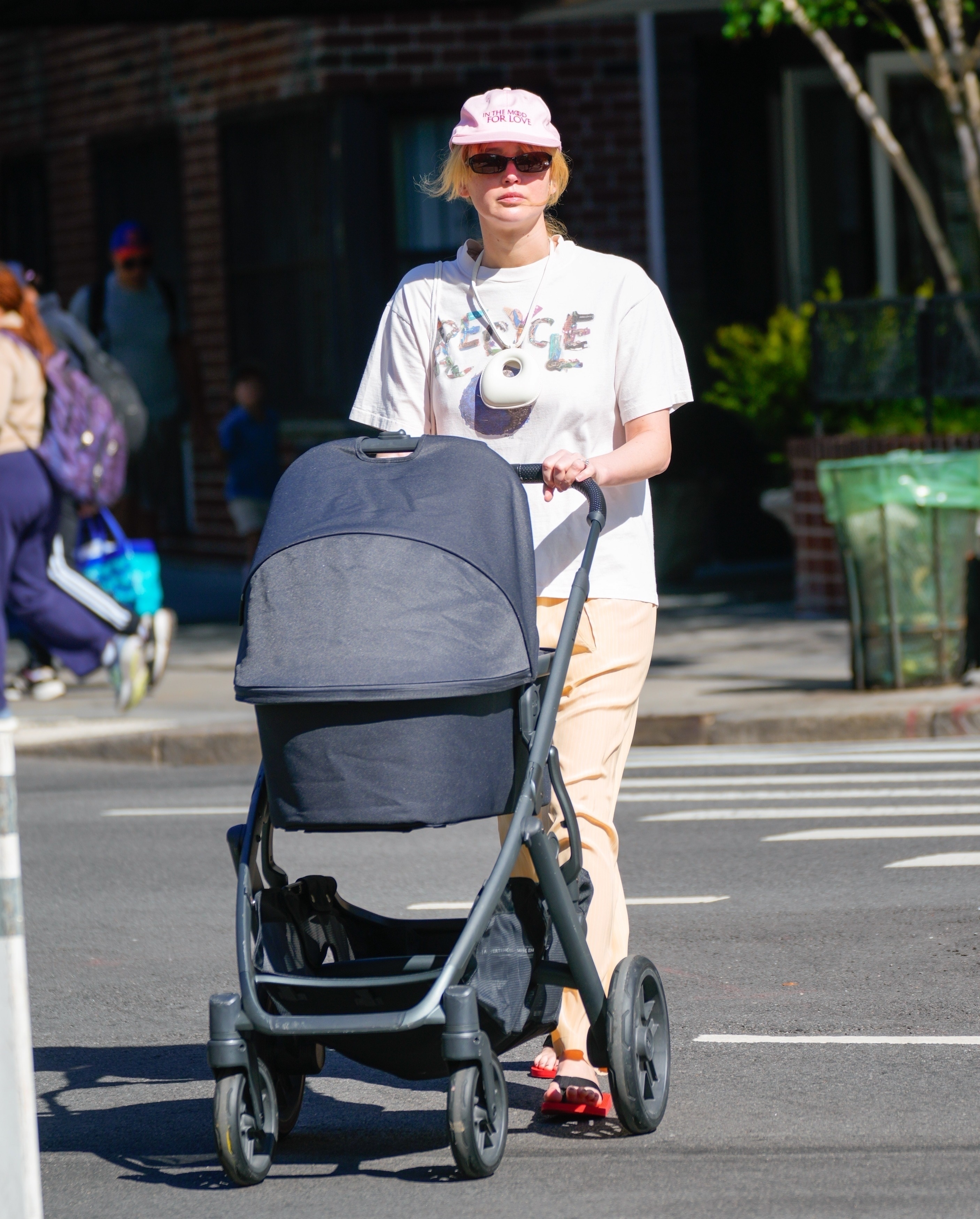 Jennifer Lawrence pushes a baby carriage outdoors. 
