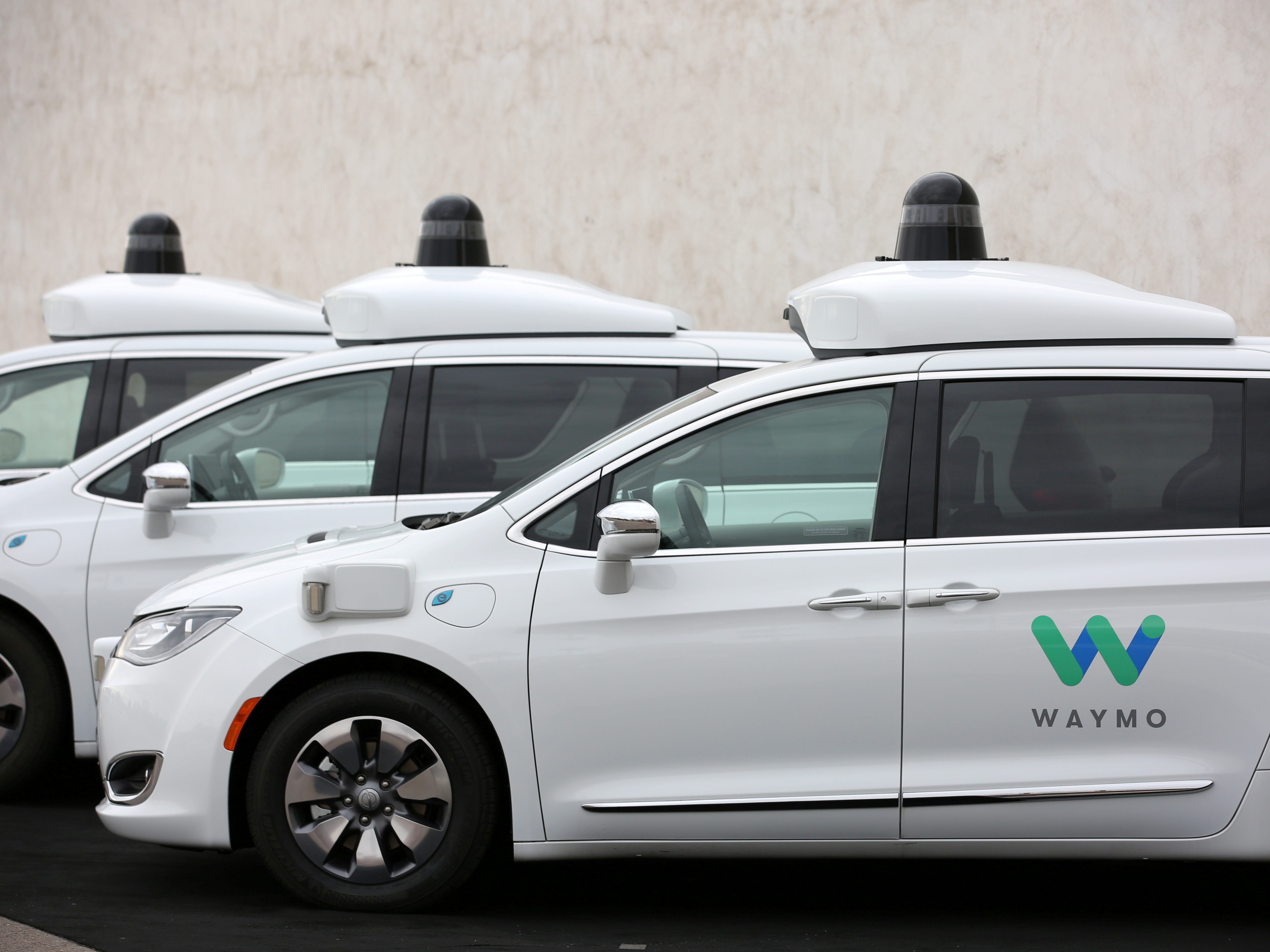 FILE PHOTO: Three of the fleet of 600 Waymo Chrysler Pacifica Hybrid self-driving vehicles are parked and displayed during a demonstration in Chandler, Arizona, November 29, 2018. REUTERS/Caitlin O’Hara/File Photo