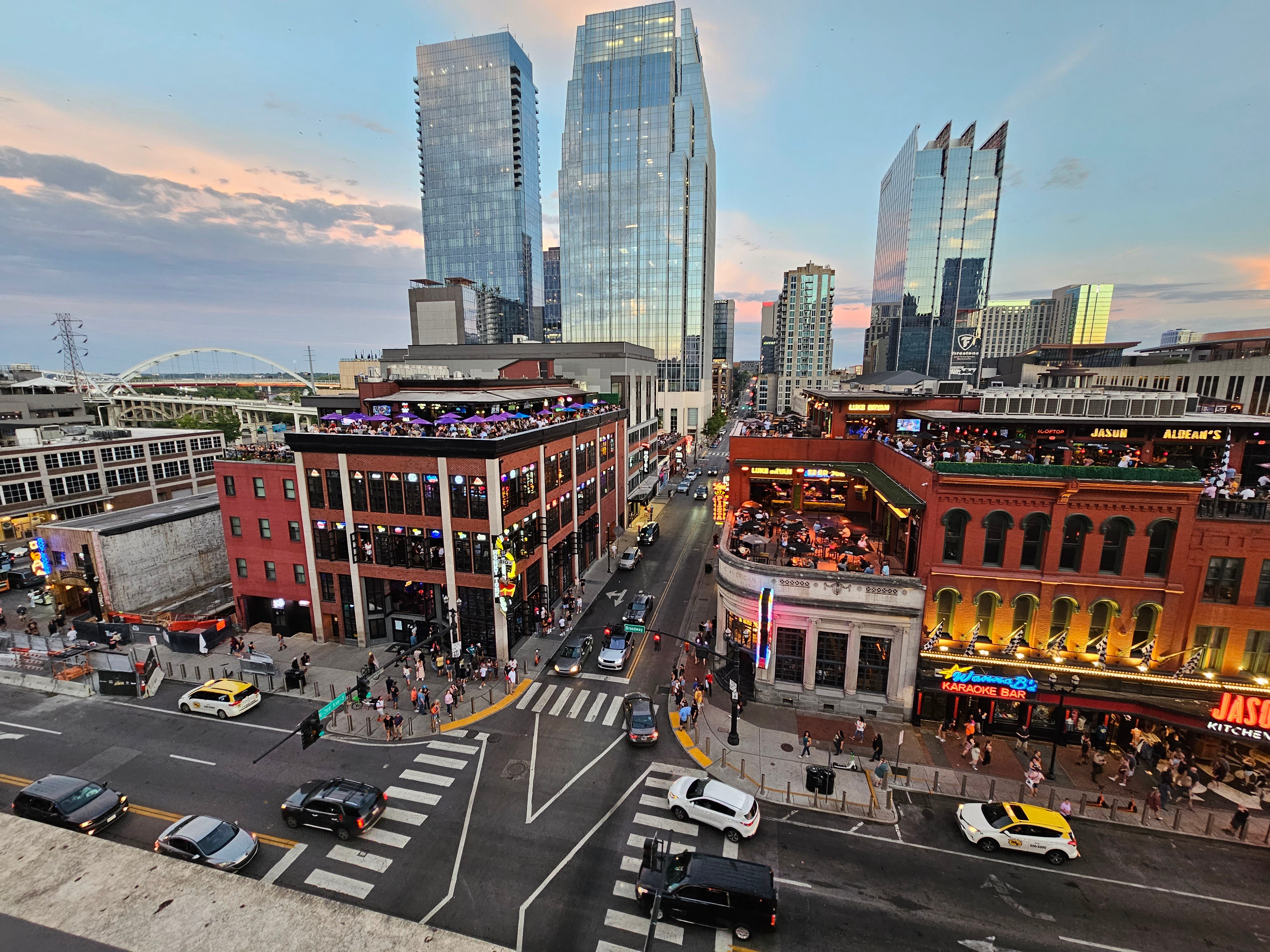 Aerial view of downtown Nashville streets with cars and lit-up venues