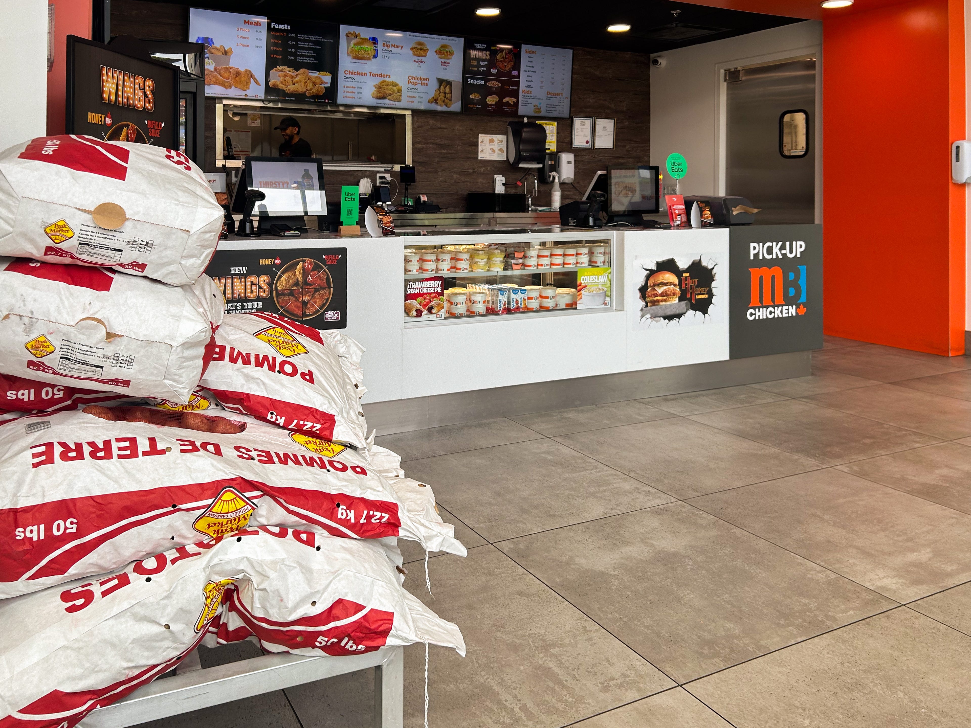 Inside a Mary Brown's Chicken in Vancouver with stacks of potato bags on the left and the ordering counter on the right