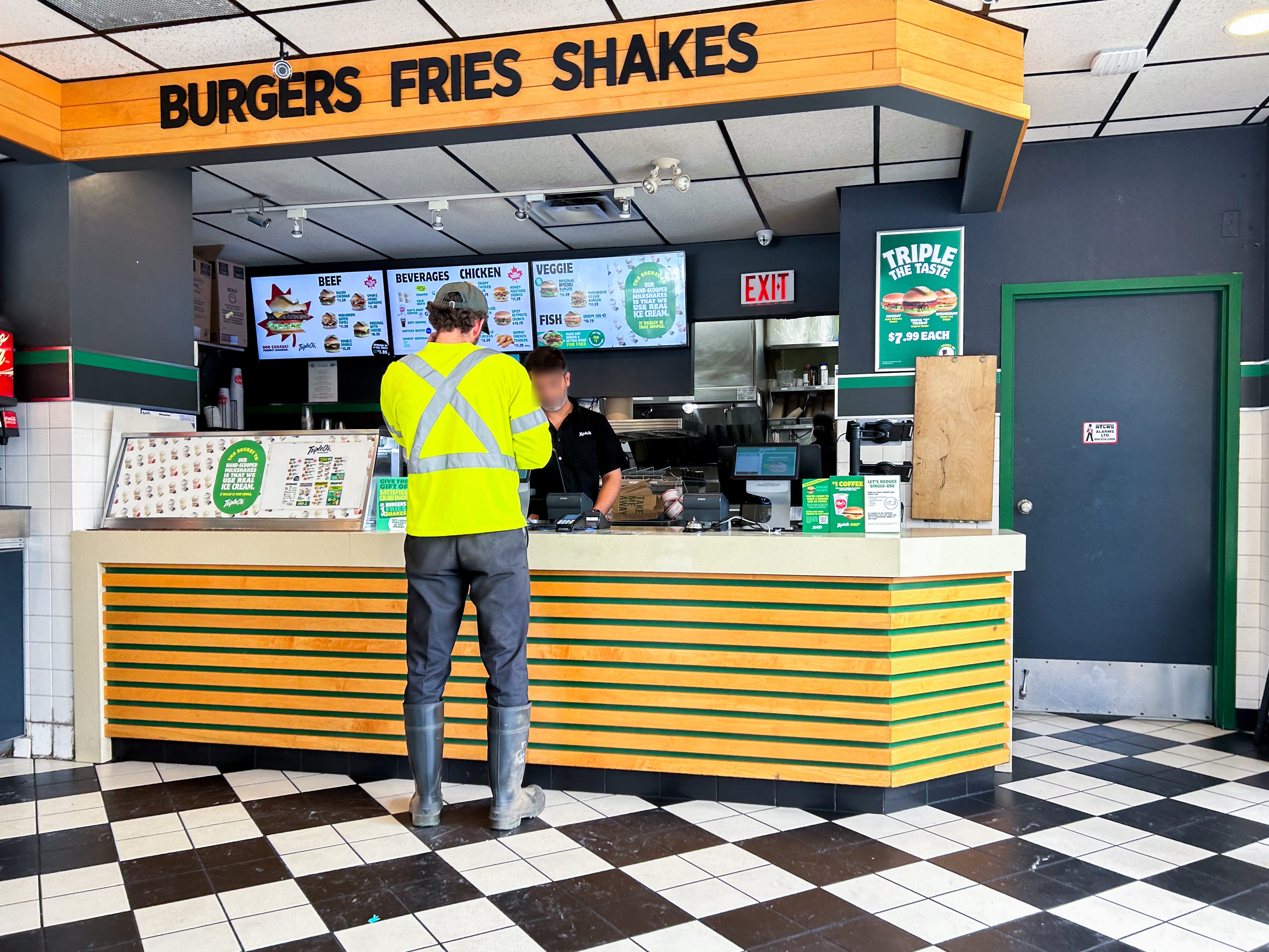 A patron orders at the counter at Triple O's in Vancouver, British Columbia