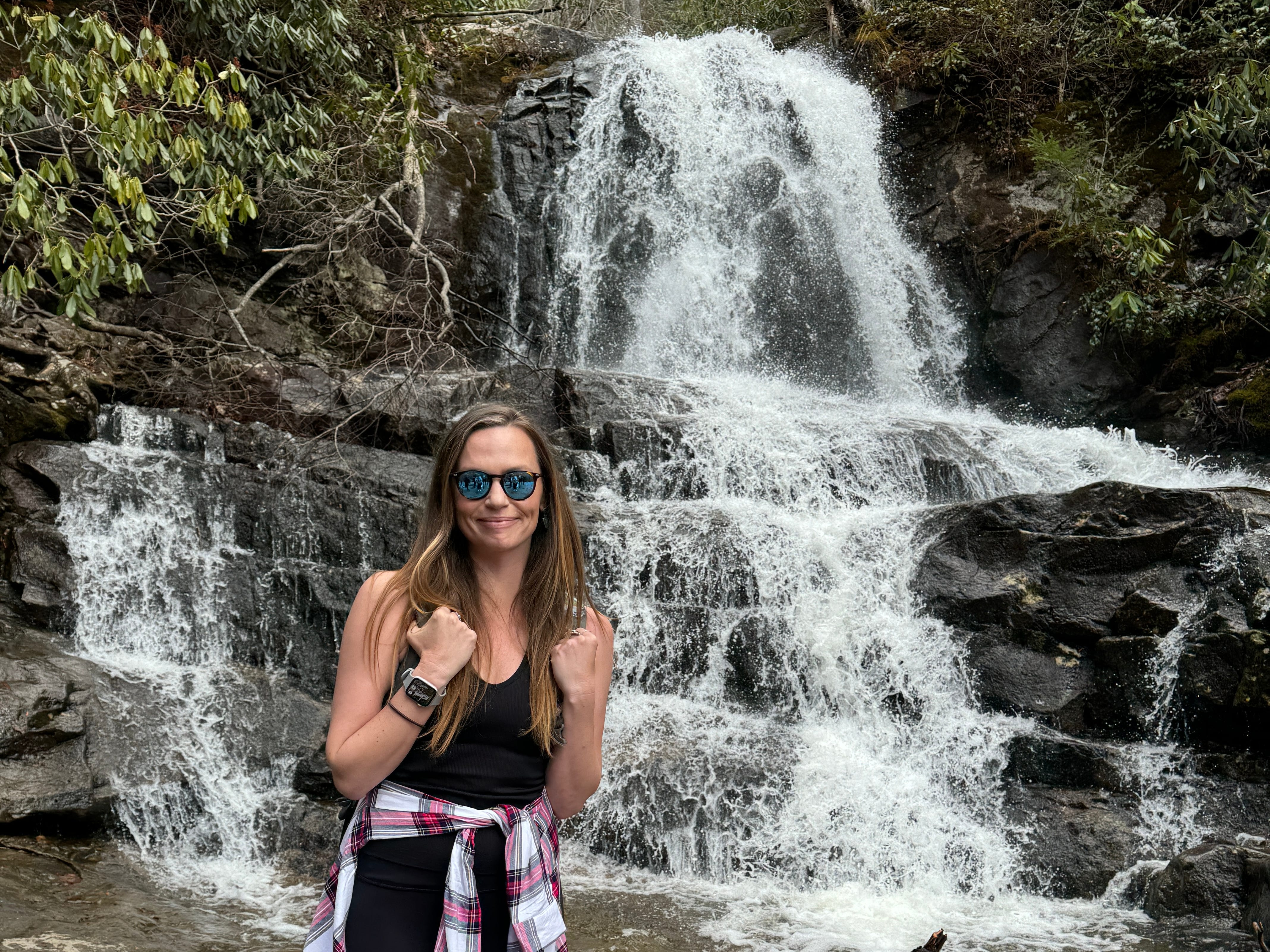 Emily stands in front of a roaring waterfall at Great Smoky Mountains National Park.