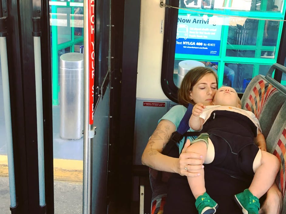Woman sleeping on bus with baby on her lap