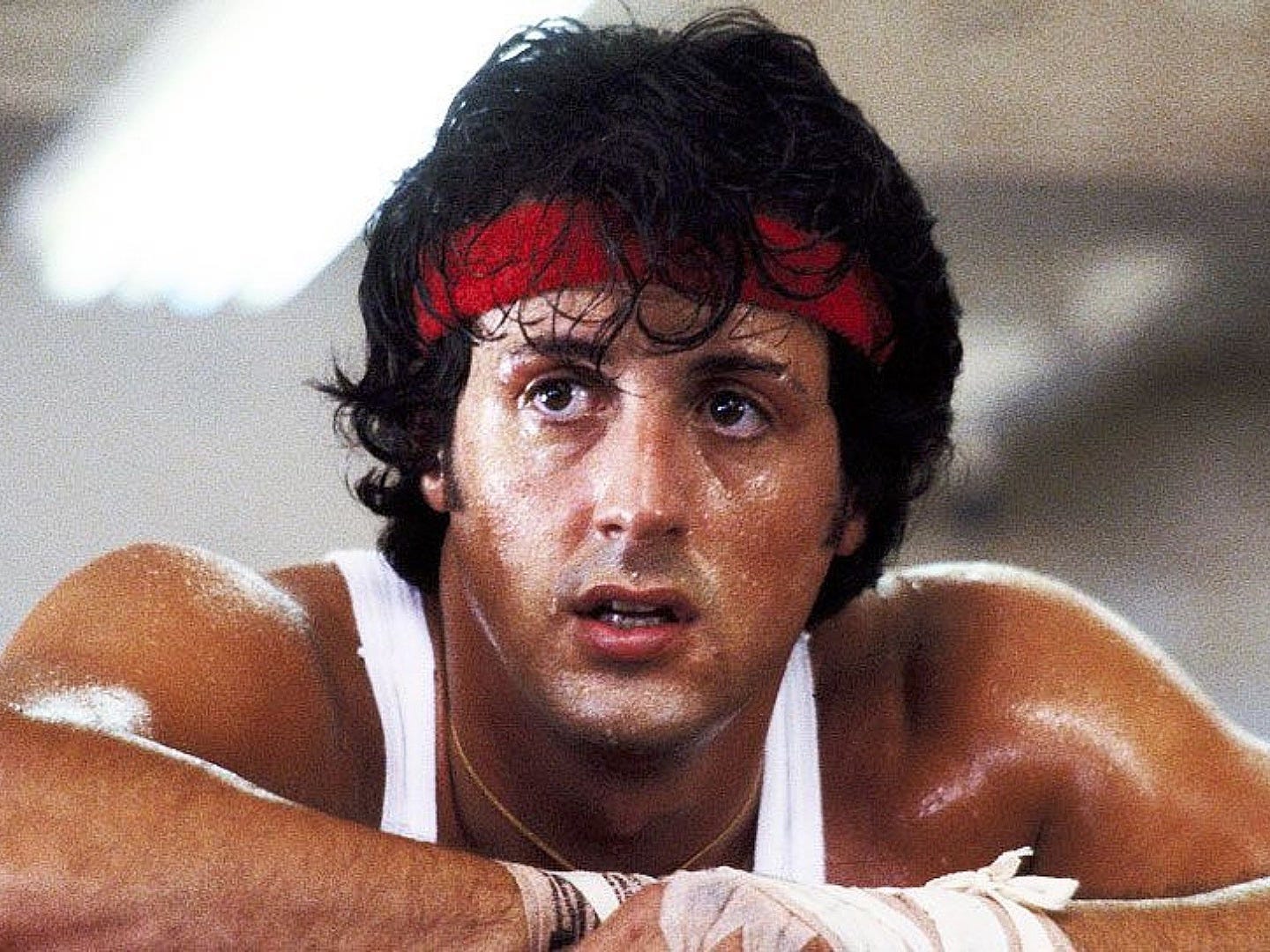 Sylvester Stallone sweaty with a red head band