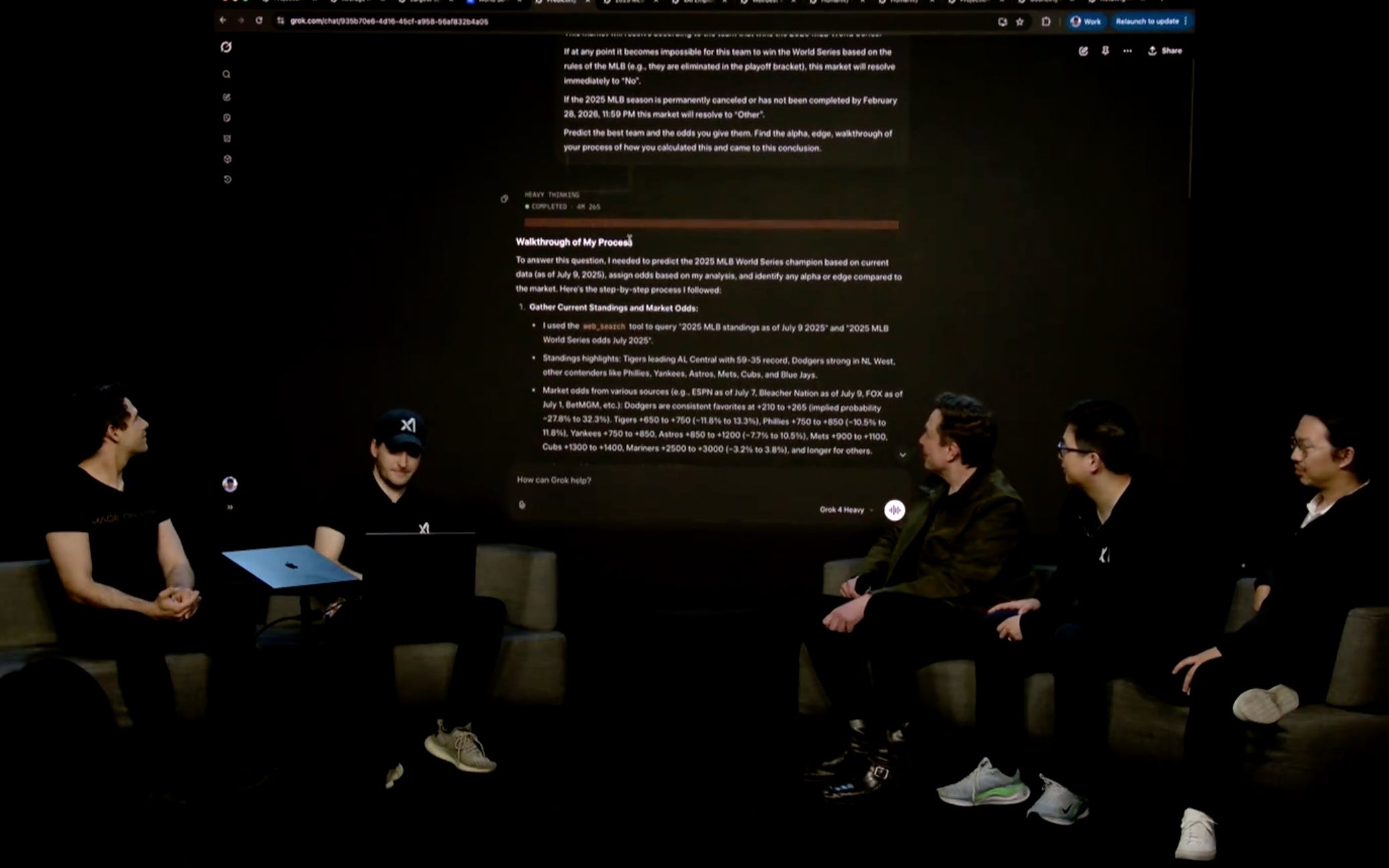 Elon Musk and a panel of xAI employees are pictured presenting Grok-4.