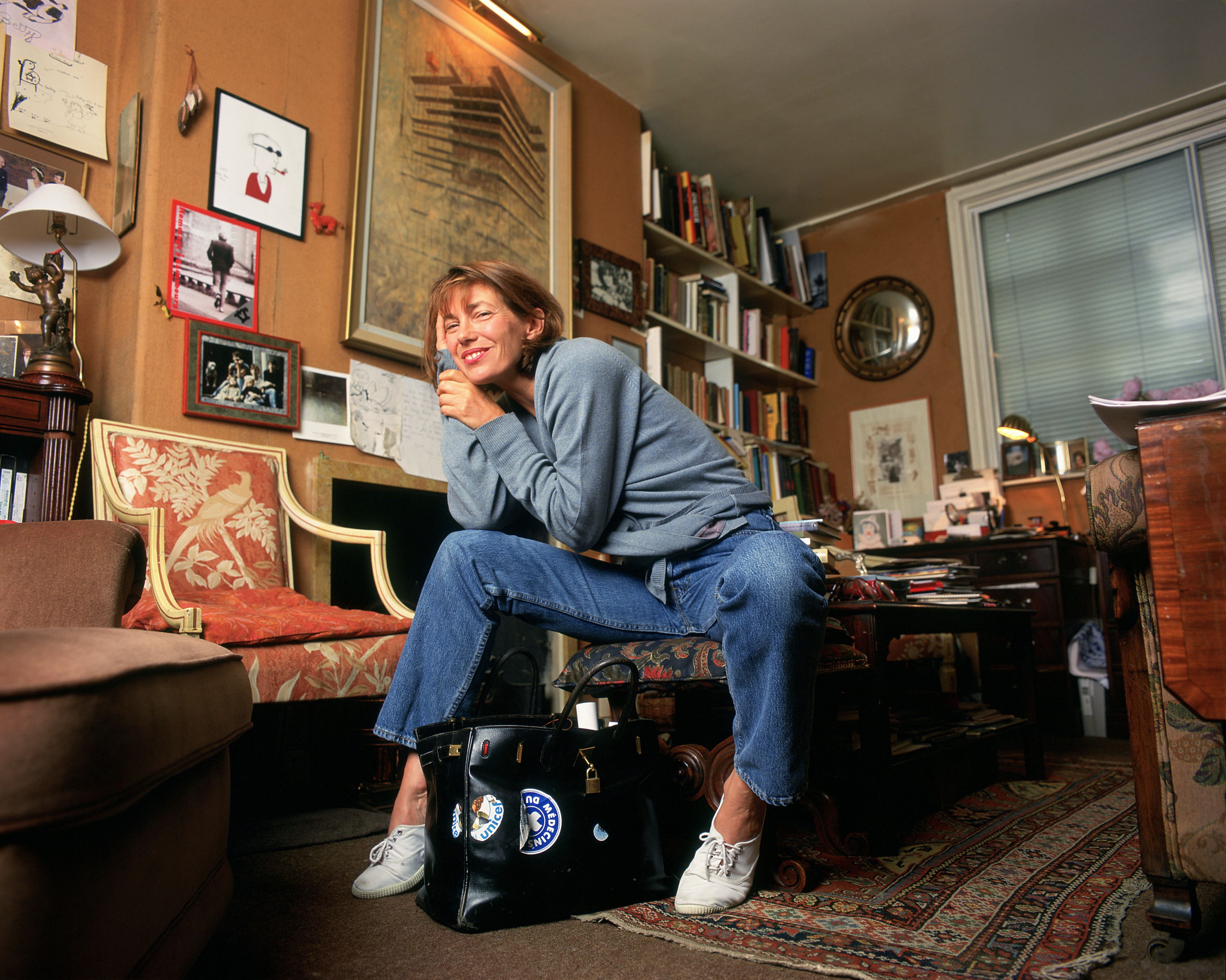 Jane Birkin sitting next to her Birkin bag