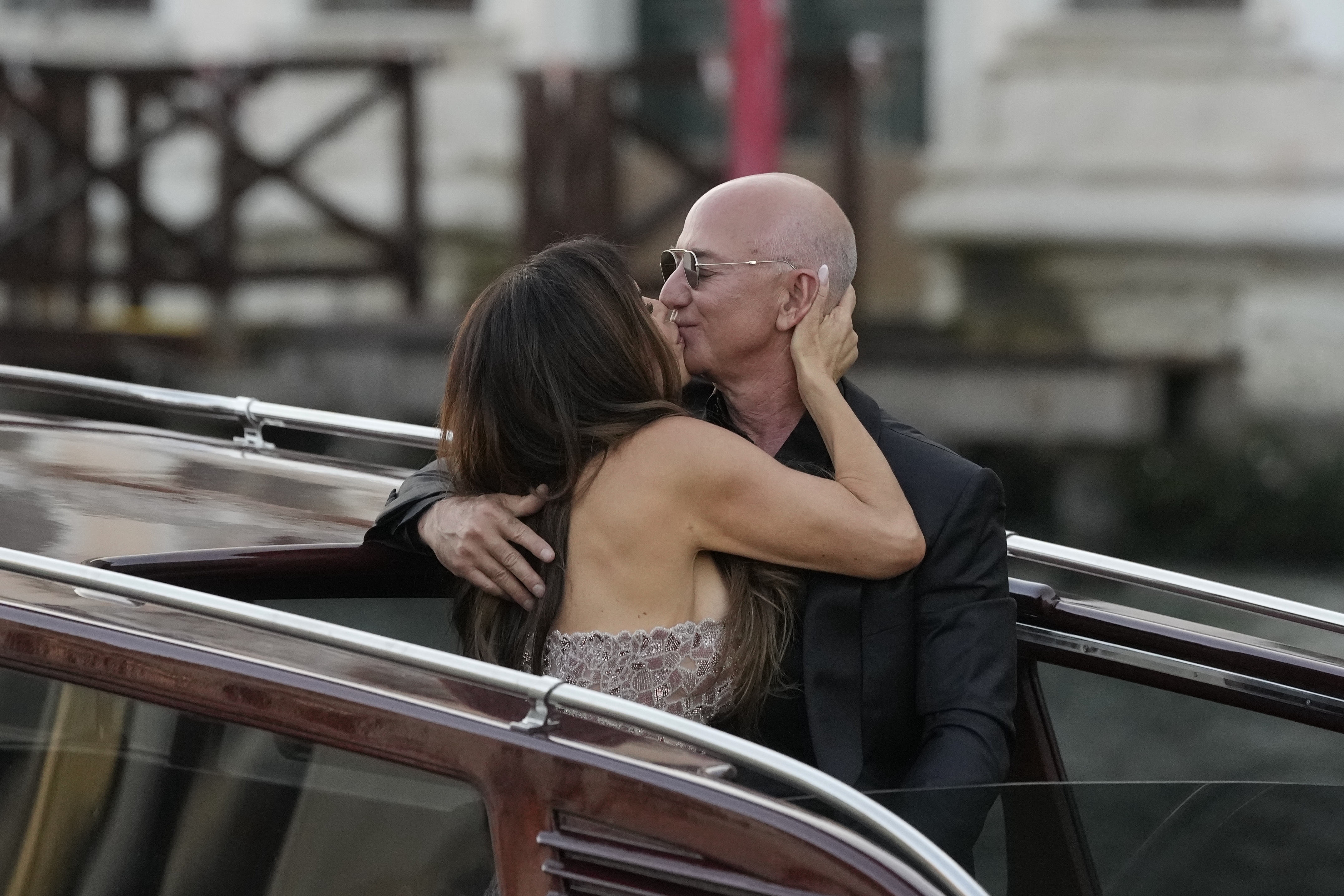Jeff Bezos and Lauren Sánchez kiss on a water taxi. 