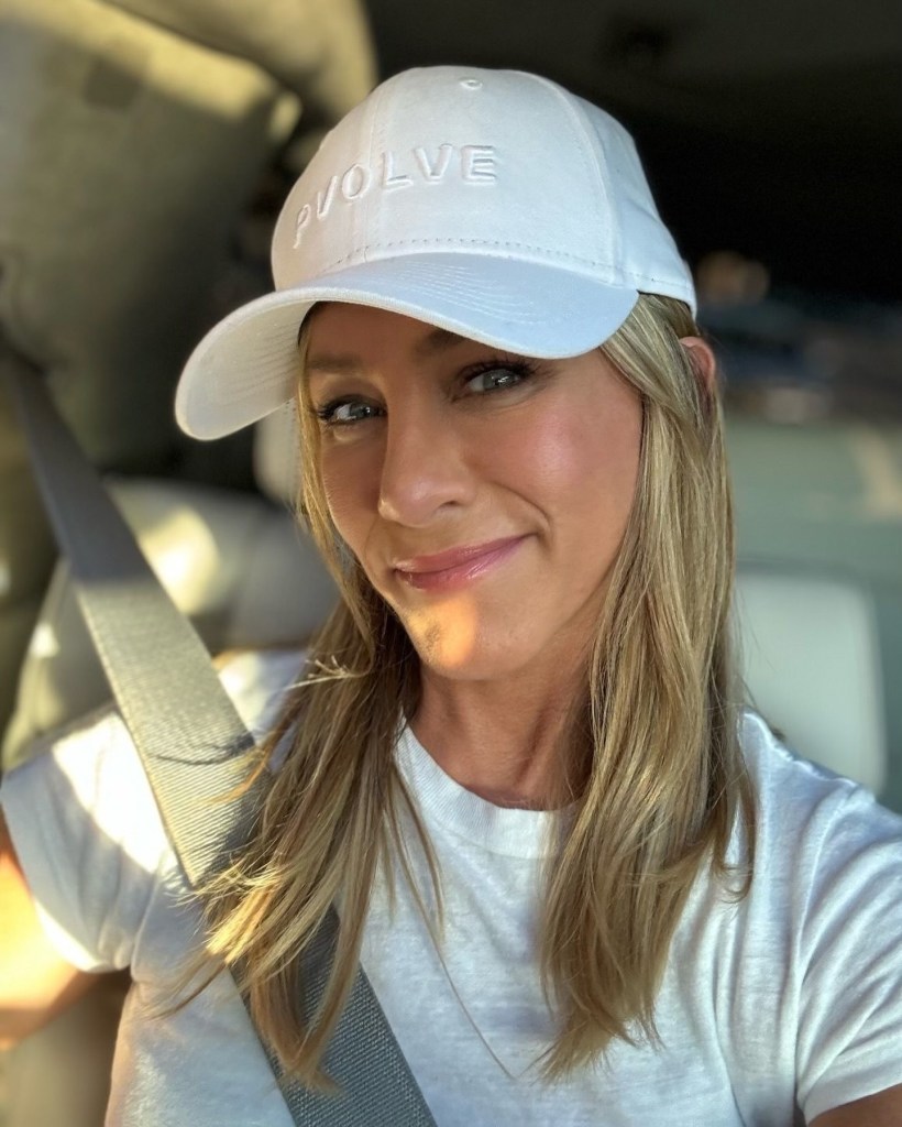 Jennifer Aniston taking a selfie in a baseball cap.