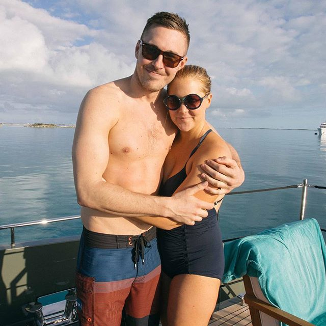 Amy Schumer in a black swimsuit with her husband. 