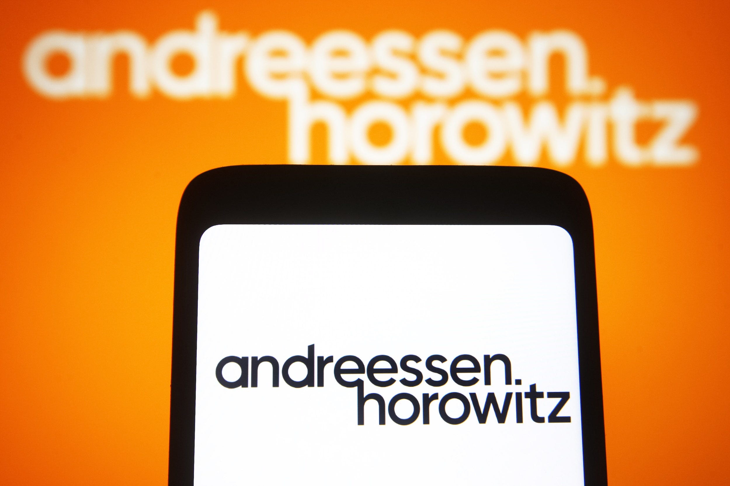 The Andreessen Horowitz logo is seen on a smartphone and a computer screen.
