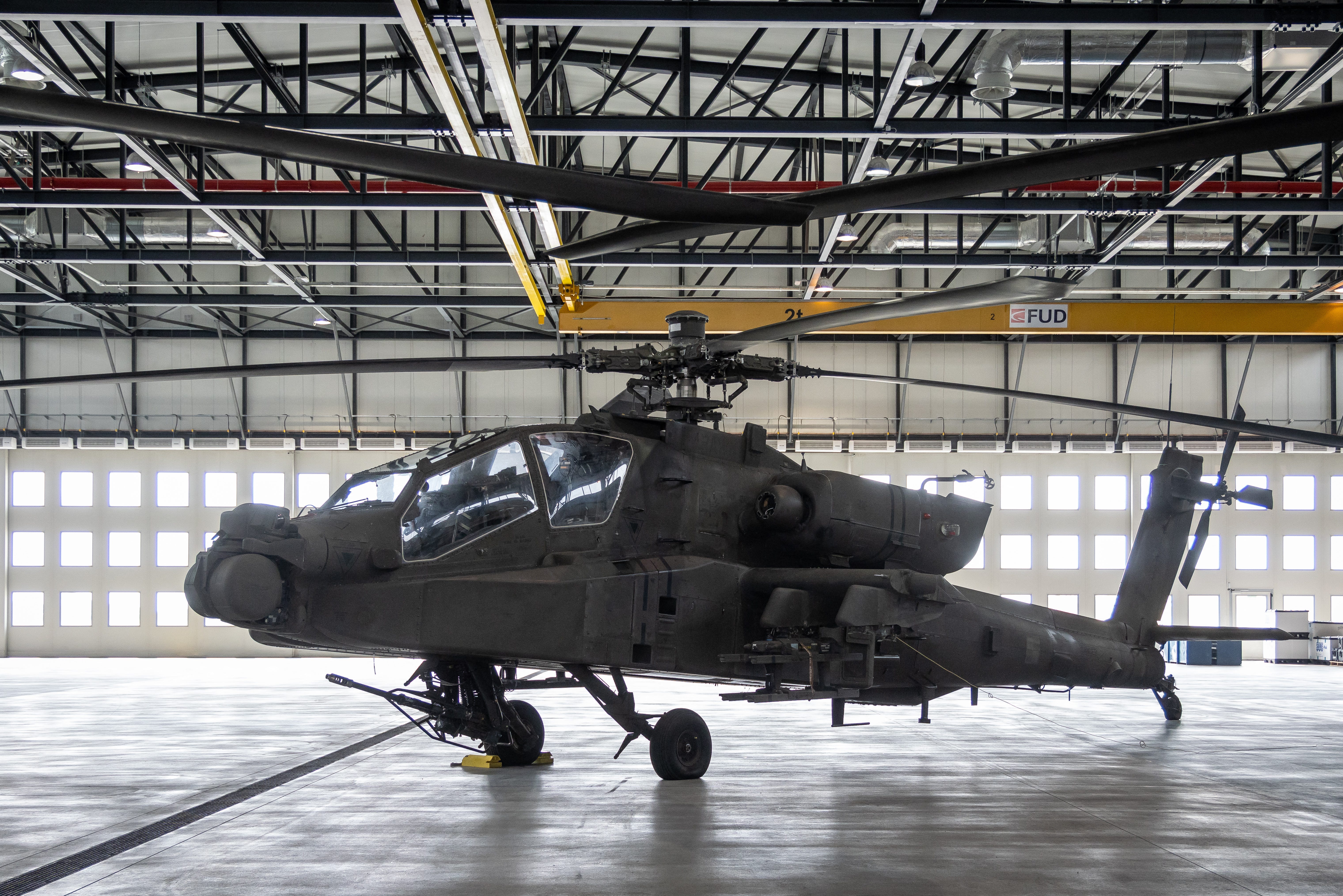 An AH-64D APACHE helicopter stands in the hangar during a ceremony marking the delivery of the first helicopters of this kind to the Polish Armed Forces under a lease agreement with the US Army.