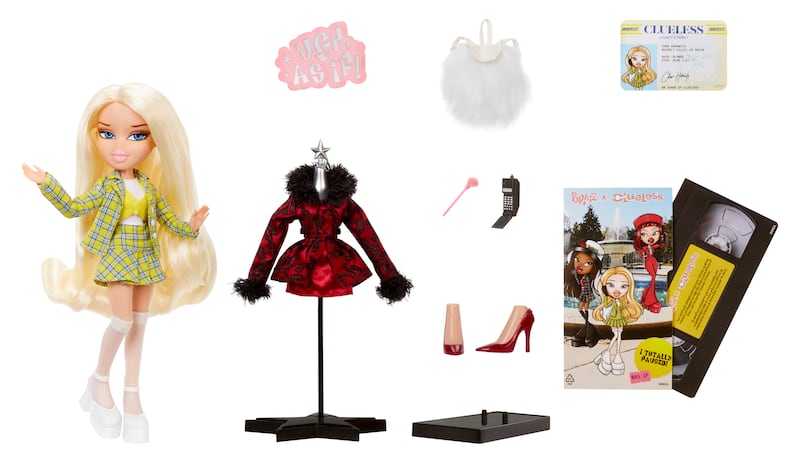 The Bratz x Clueless Cher collector doll is pictured with her second outfit, platform heels, flip phone, fluffy pen, driver’s permit, CD, and matching purse.