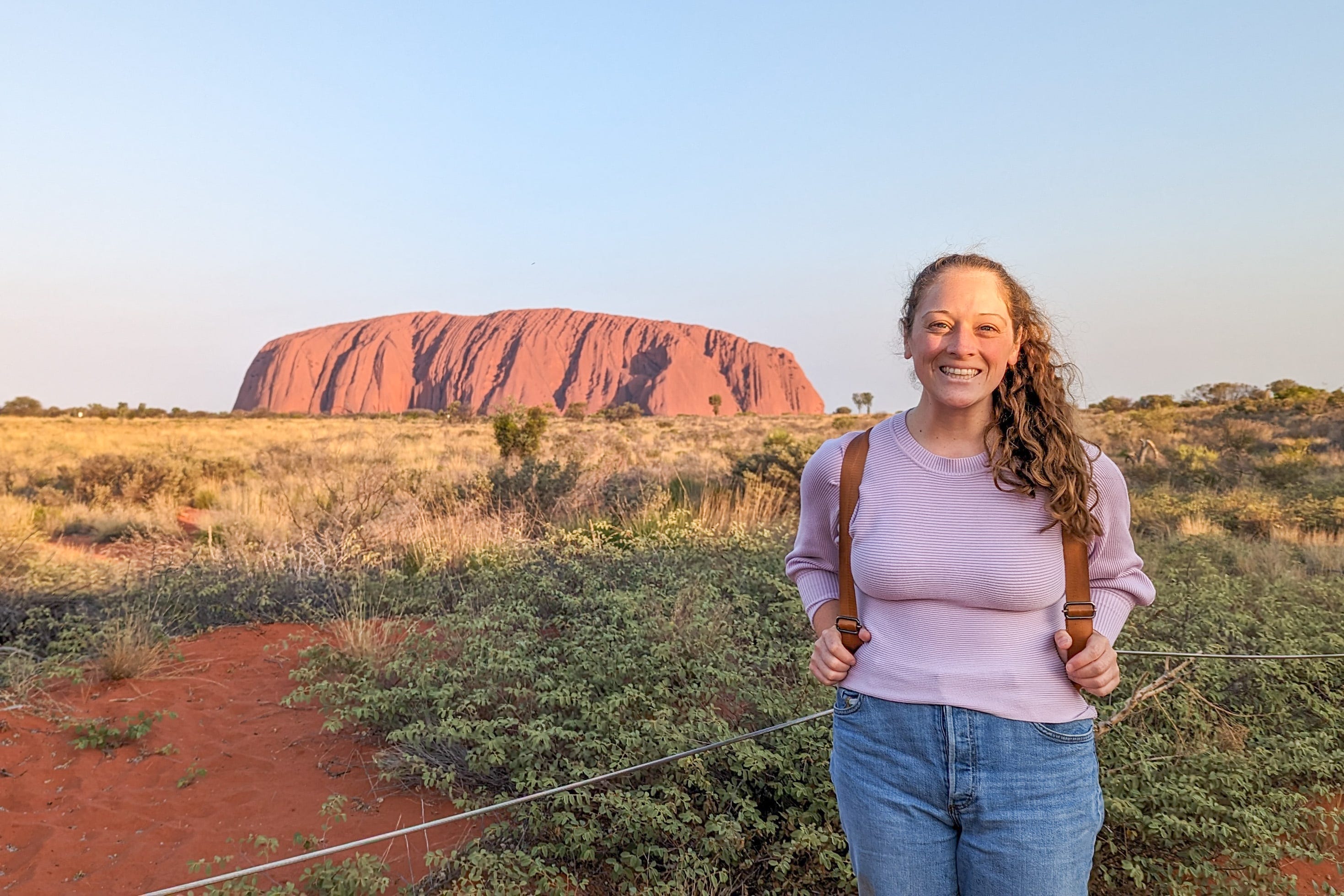 Author Jenna DeLaurentis smiling at Uluru