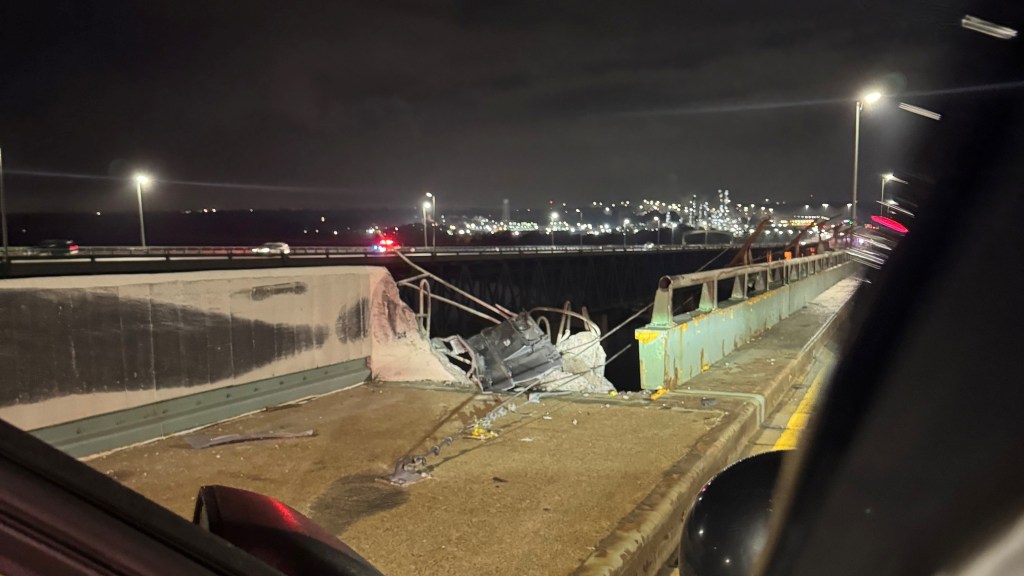 Debris from a tractor-trailer crash on a bridge.