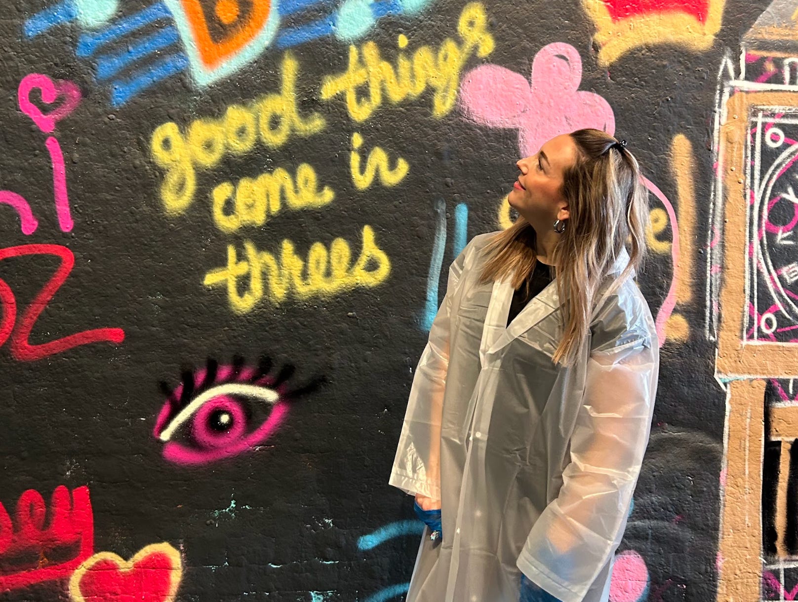 The writer posing in front of a graffiti-covered wall in London.
