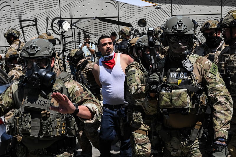 Law enforcement officers, including members of the Immigration and Customs Enforcement (ICE) Special Response Team and Homeland Security agents, arrest a demonstrator outside the Federal Building as protests continue in response to federal immigration operations in Los Angeles on June 10, 2025. Hundreds of Marines are due to arrive in Los Angeles on June 10 after US President Donald Trump ordered their deployment in response to protests against immigration arrests and despite objections by state officials. The 700 troops will join National Guard soldiers, amping up the militarization of the tense situation in the sprawling city, which is home to millions of foreign-born and Latino residents. The unrest was sparked by a sudden intensification of Trump's signature campaign to deport illegal migrants, with raids conducted on workplaces. (Photo by RONALDO SCHEMIDT / AFP) (Photo by RONALDO SCHEMIDT/AFP via Getty Images)