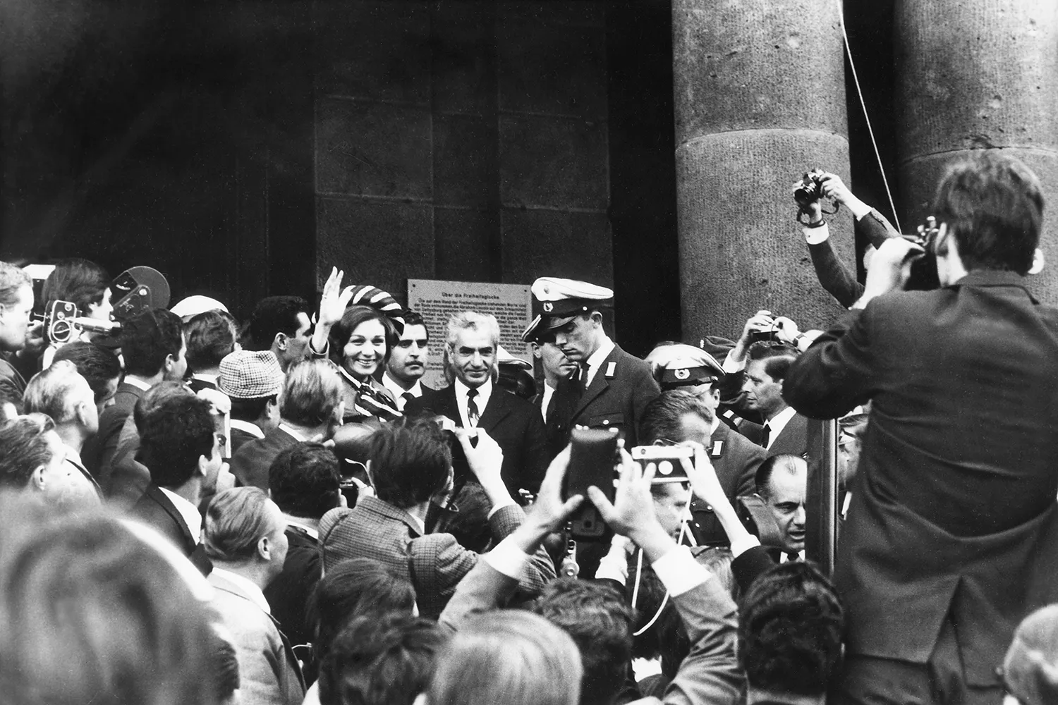 The Shah and Empress Farah Pahlavi arrive in Berlin among a large crowd of journliasts.