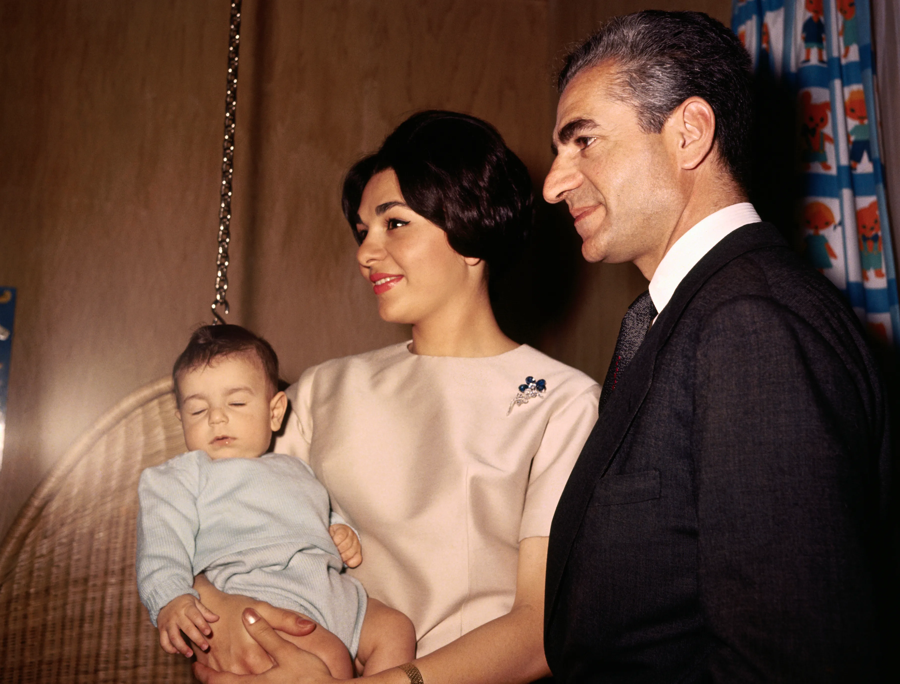 The Shah of Iran with his wife and sleeping son.