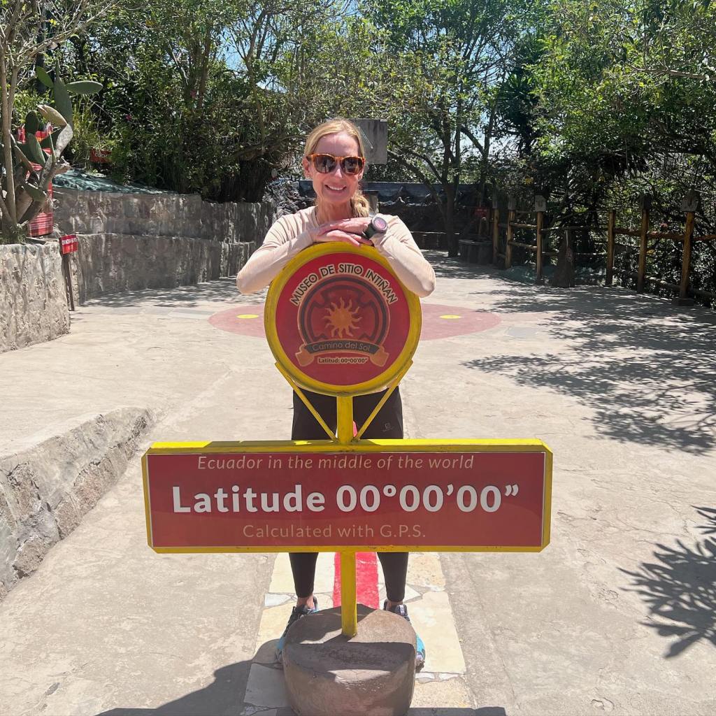 Woman standing at the equator in Ecuador.