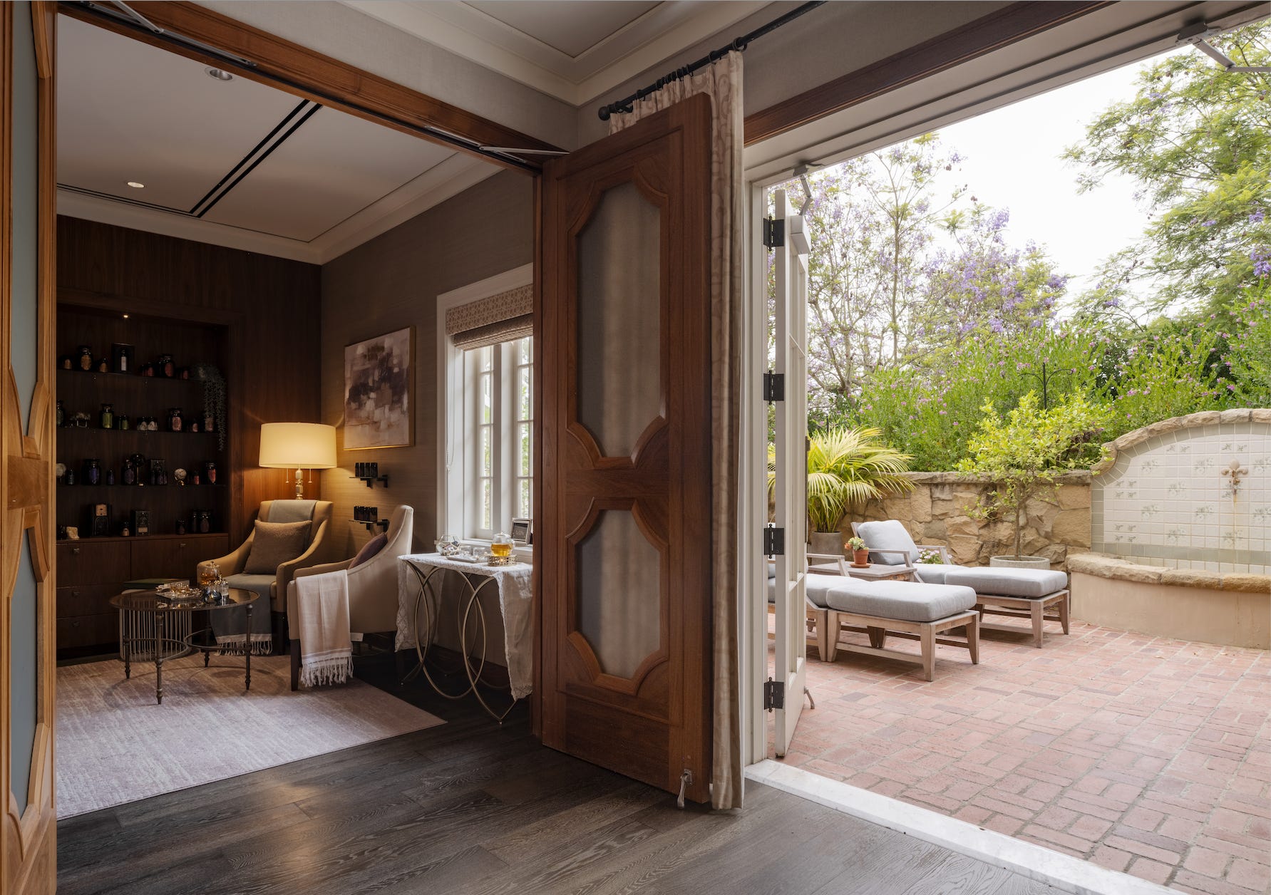 Spa with open doors leading onto a stone terrace with lounge chairs.