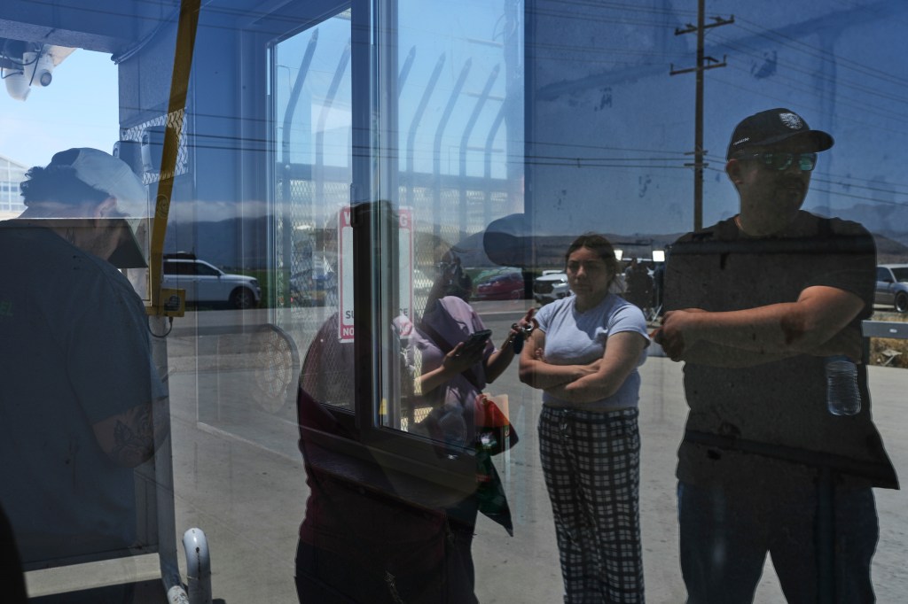 Reflection of people at a California farm during immigration raids.