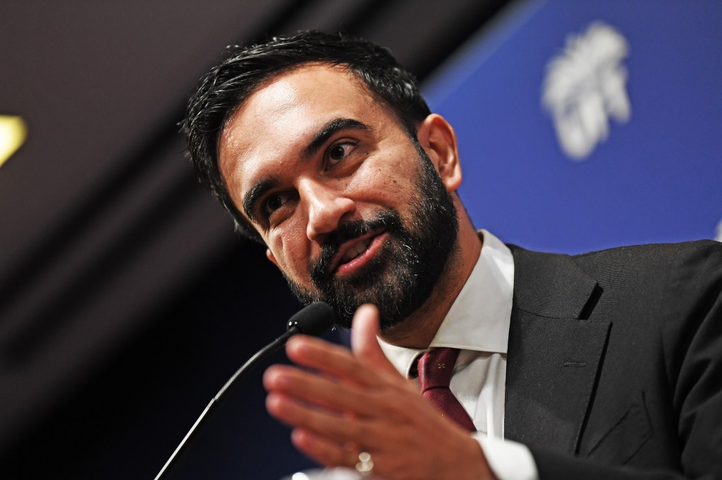 Close-up of Zohran Mamdani speaking at a podium.